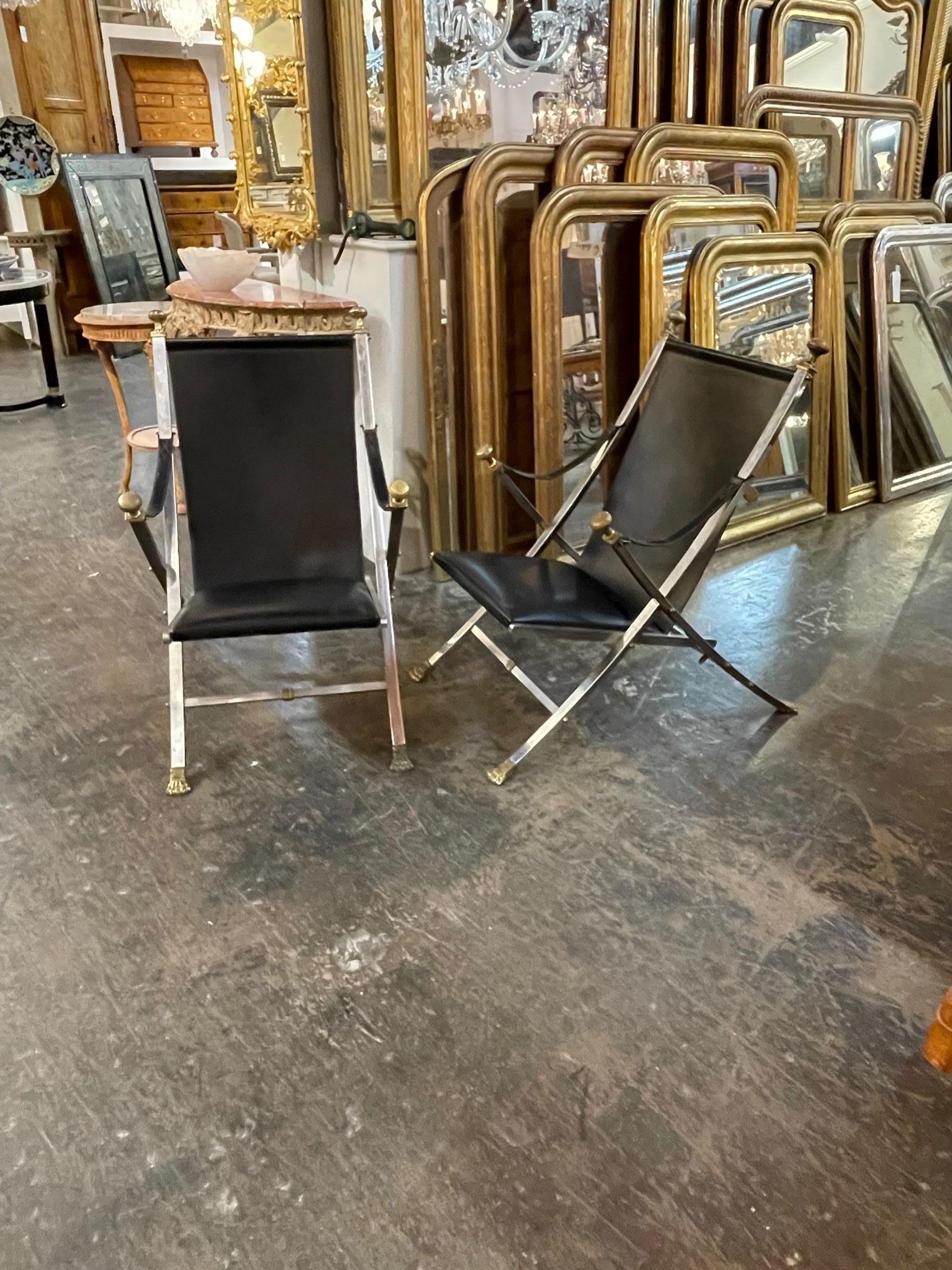Rare pair of French Maison Jansen polished steel and leather folding chairs. Circa 1940. These are sure to make a statement in any space.