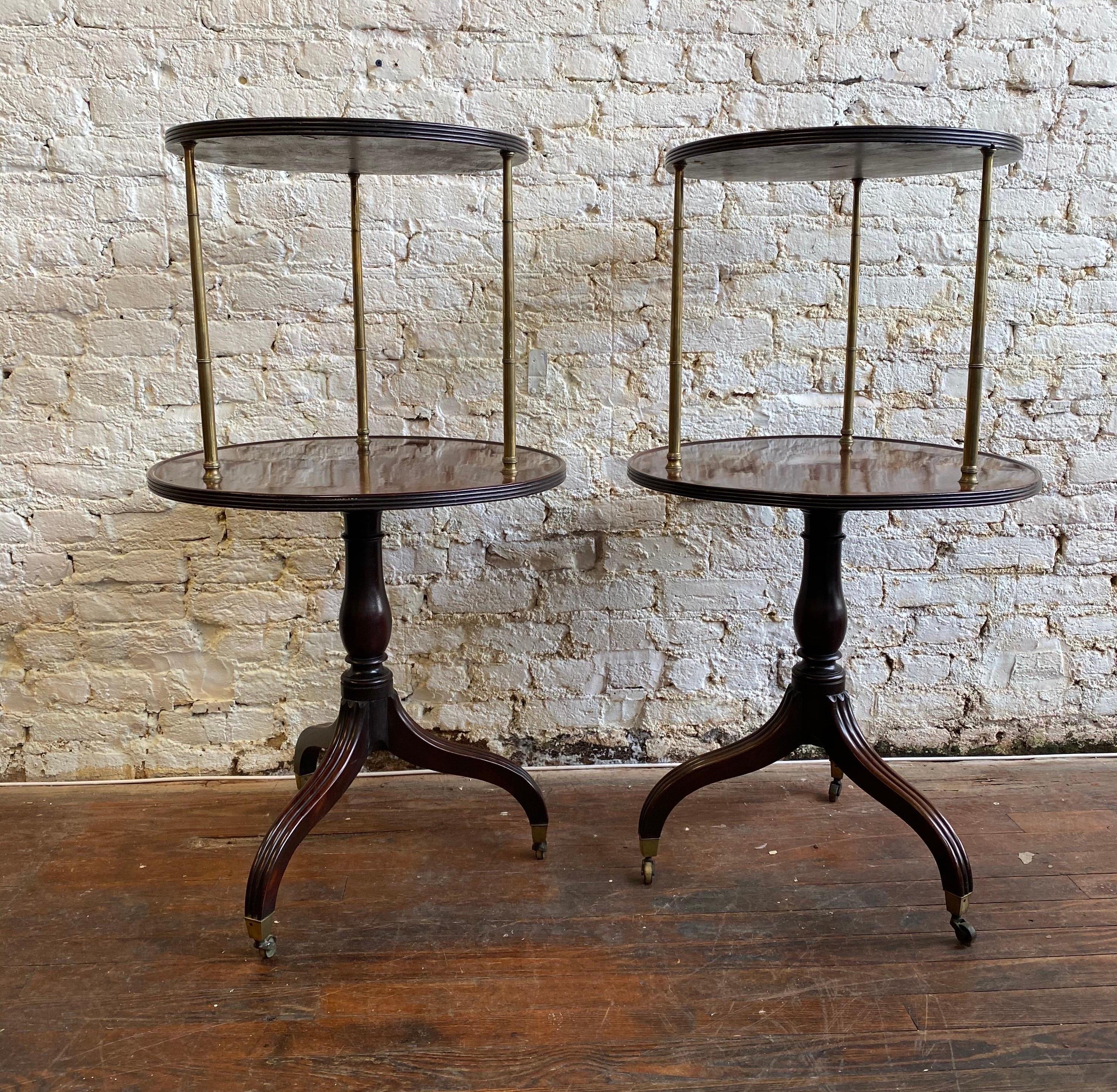 Rare pair of Georgian mahogany dumbwaiters on turned bases, reeded legs and original castors with brass columns separating the two solid mahogany tops. Incredible quality.