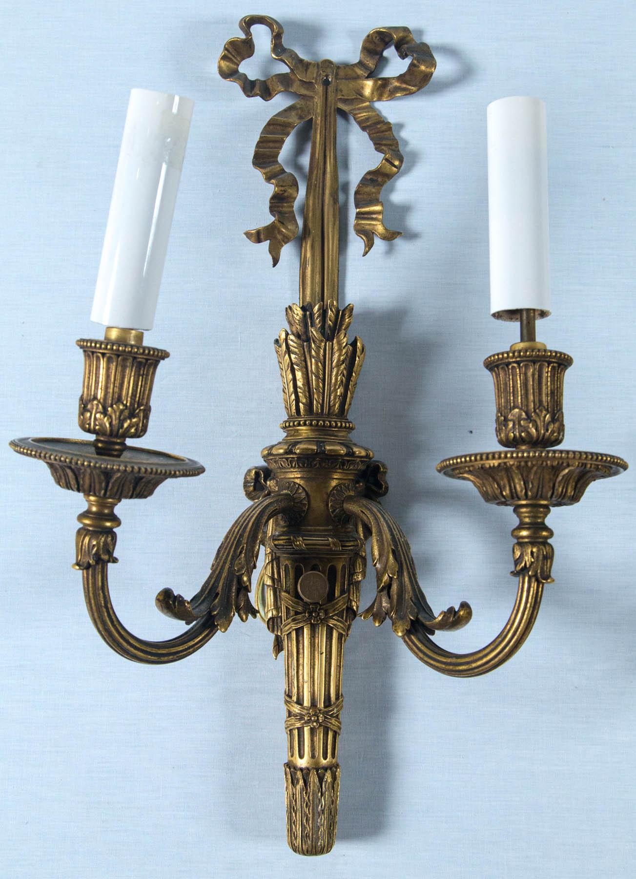 A rare pair of gilt bronze circa 1900 E F Caldwell sconces. Made in the French Louis XVI iconic style with high quality crisp casting and rich gilt bronze patina now nicely tarnished and aged. Original mark of C with diamond border stamped on back