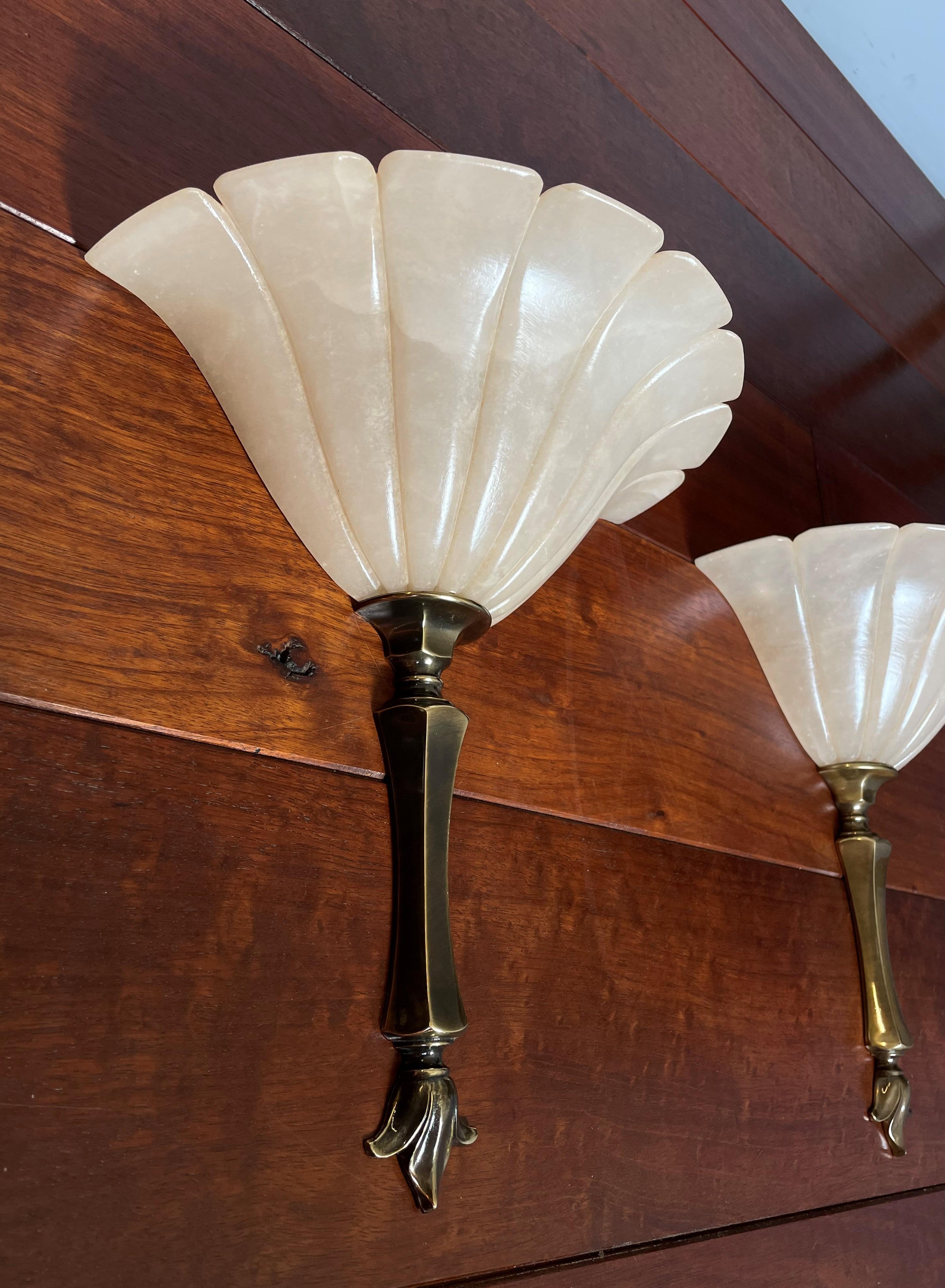 Excellent condition alabaster sconces with stunning patterns in their alabaster shades.

This finest and very rare French pair of alabaster sconces is both beautiful in shape and practical in size. Hand-crafted and with a brass stem and lily