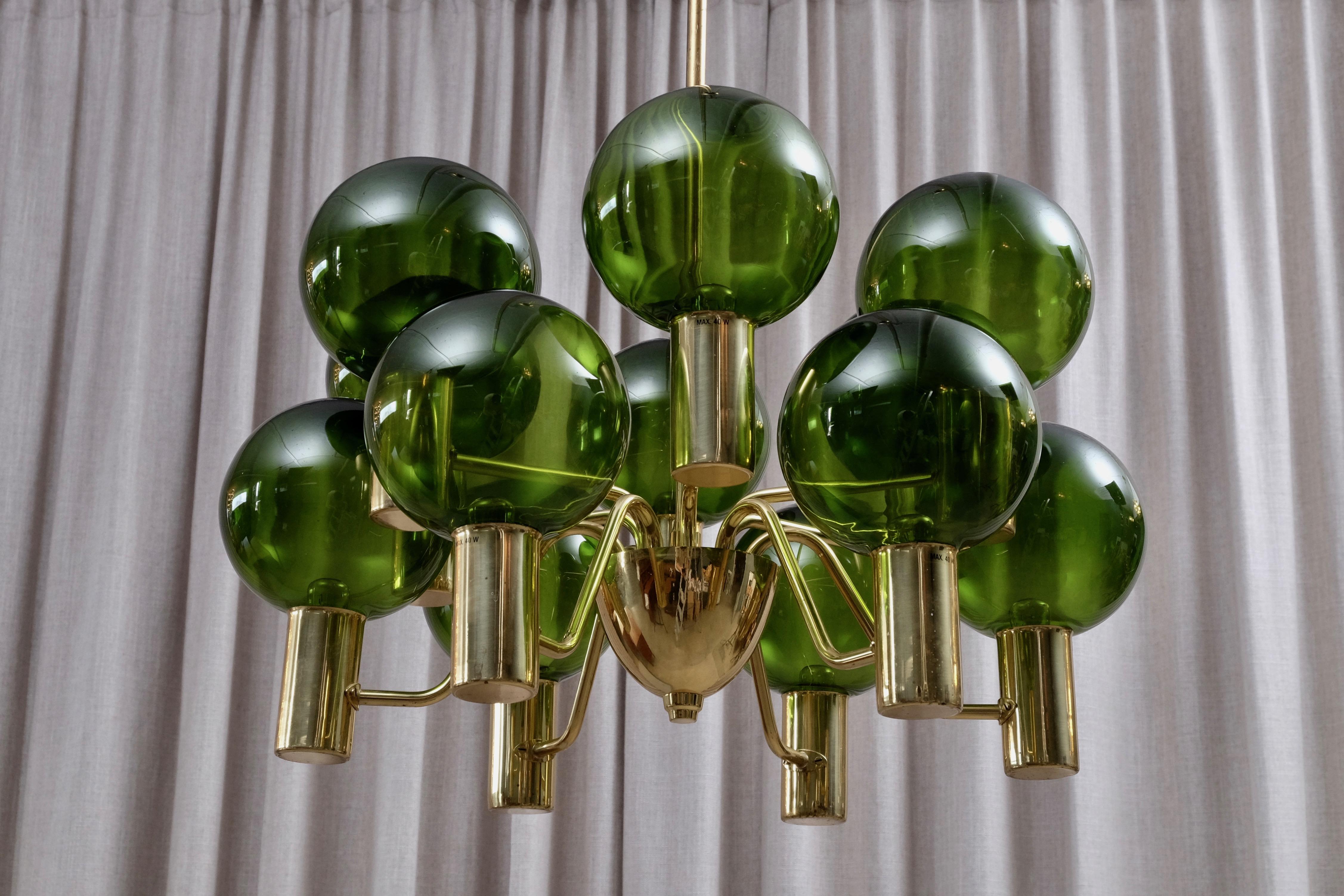 Produced by Hans-Agne Jakobsson AB in Markaryd, Sweden, 1960s.
Frame in polished brass. Green blown glass. 
Listed price is for one (1) chandelier.
 