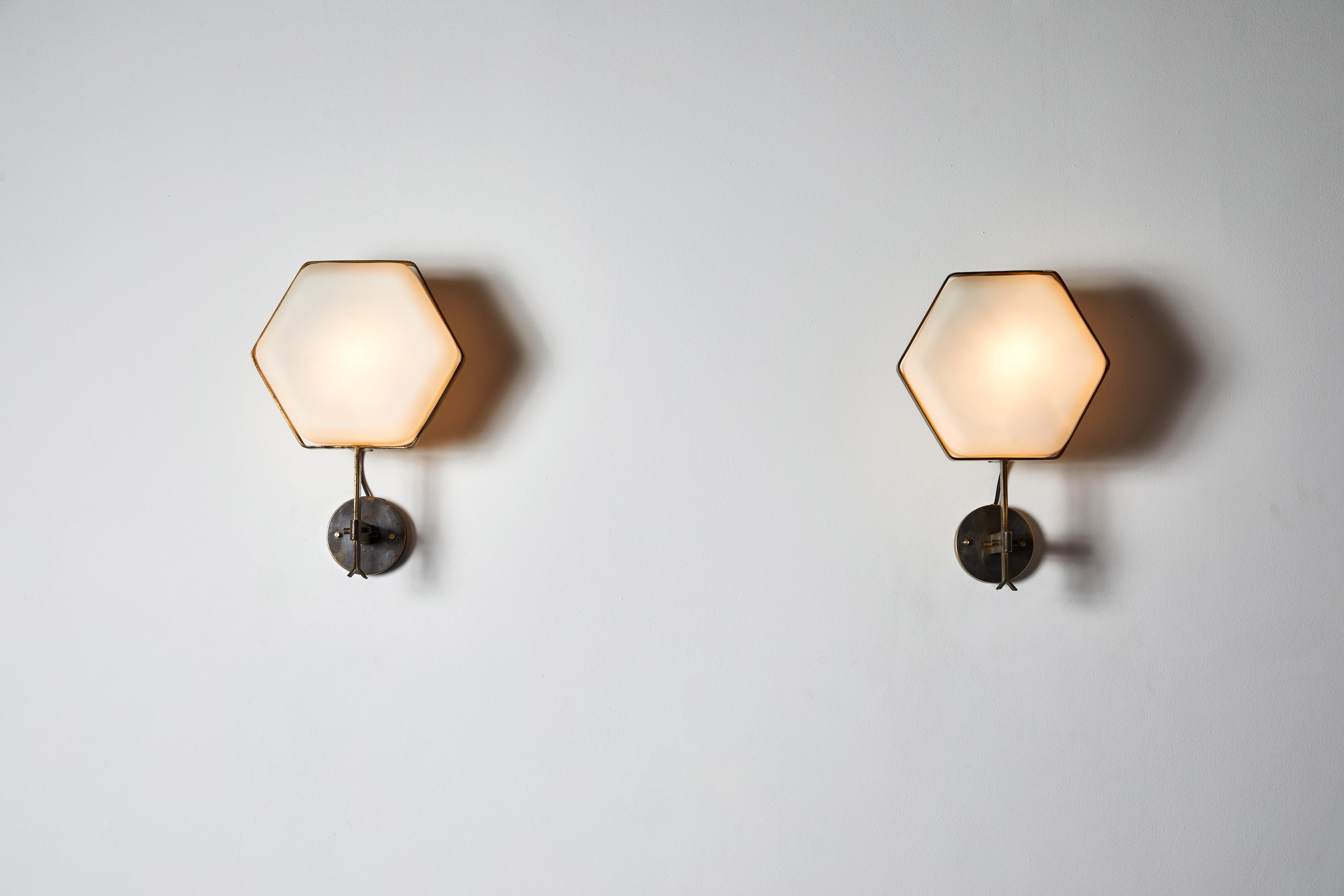 Rare pair of hexagonal sconces by Stilnovo. Manufactured in Italy, circa 1950s. Brushed satin glass diffusers, brass. Rewired for U.S. standards. We recommend one E27 60w maximum bulb per light. Bulbs provided as a one time courtesy.