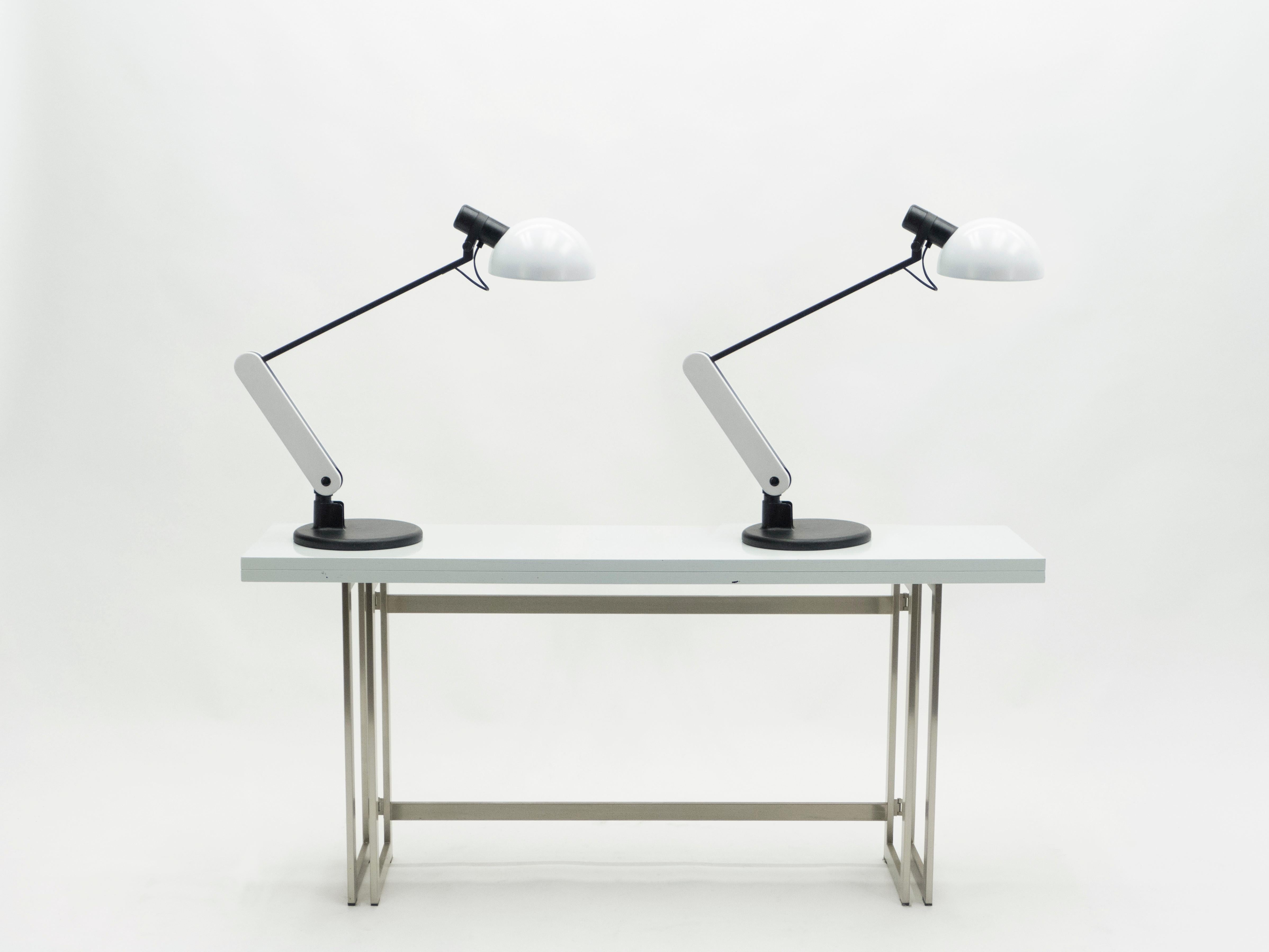 Rare pair of black and white Italian desk lamps by Harvey Guzzini with painted metal, fully adjustable, and in a typically Mid-Century Modern look. These modern-looking lamps would make a perfect addition to a contemporary or mid-century desk or,