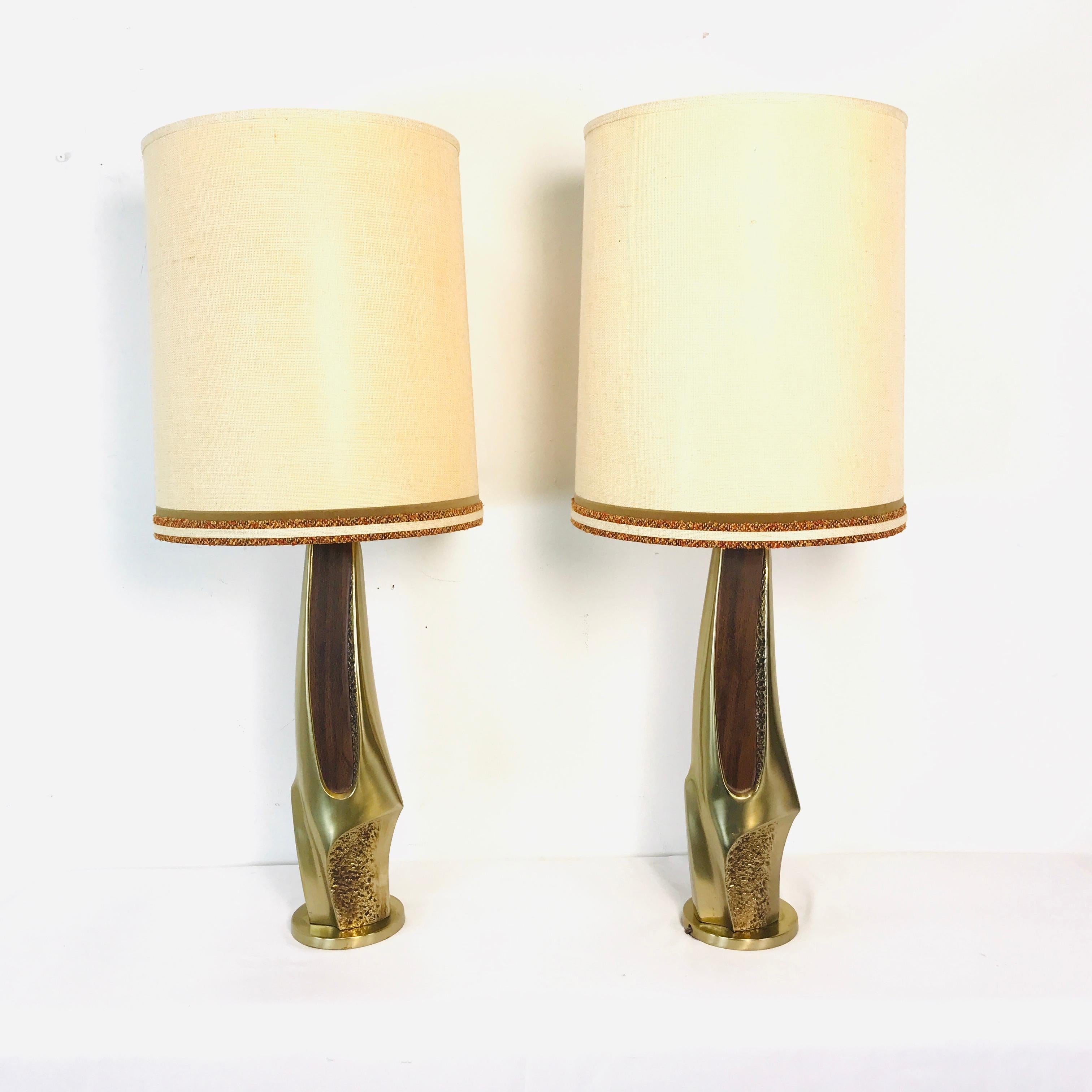 Rare pair of brass and walnut lamps designed by the Laurel Lamp Company. Beautiful organic/abstract form indicative of the 1960s. Original lamp shades and wiring in wood working order. Excellent overall quality and condition.
