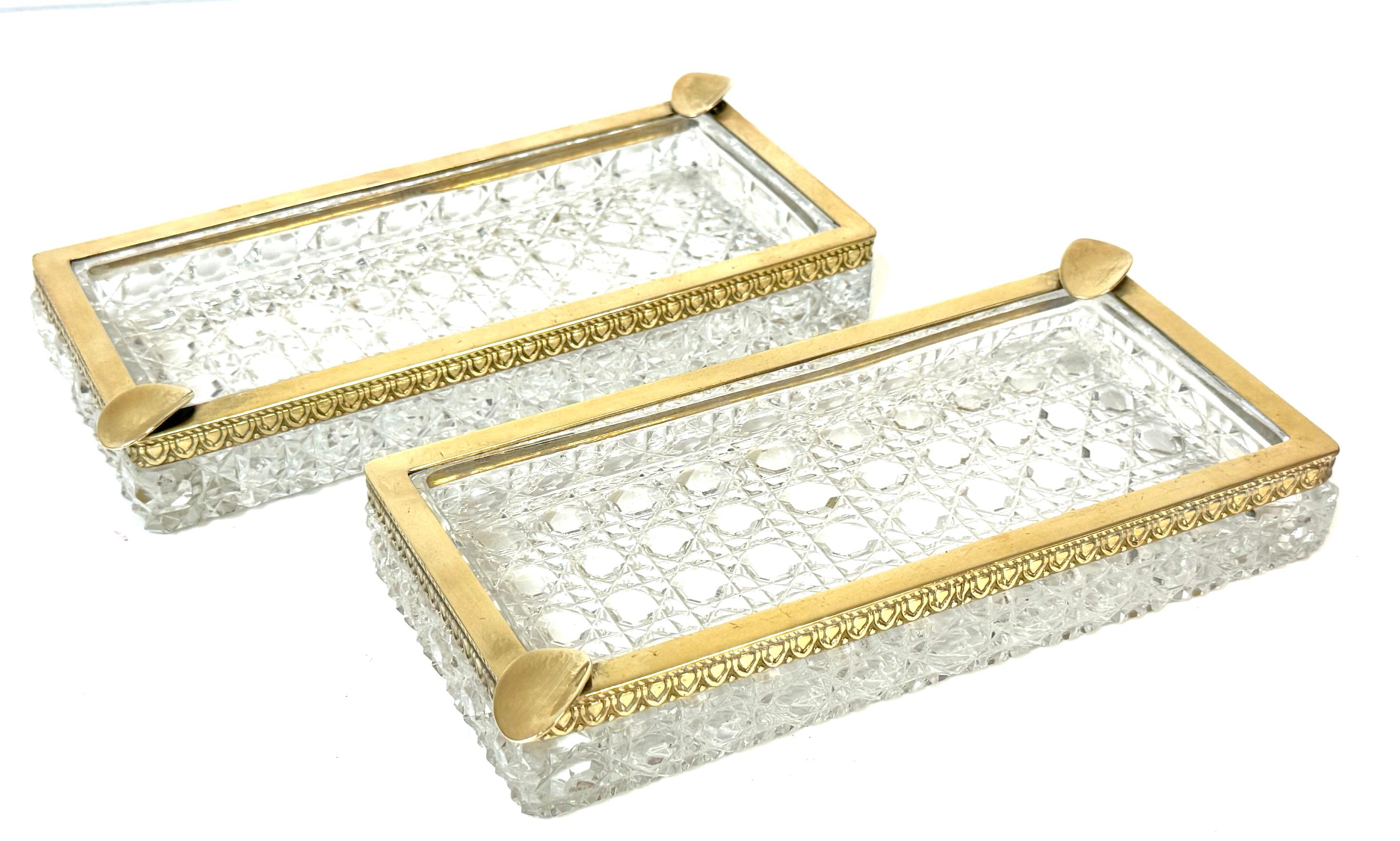 Raro par de grandes bandejas para ceniza/cigarros de cristal tallado Baccarat (atribuido), montadas en bronce, circa años 50

Un par de bandejas de cristal tallado de mediados de siglo, finamente elaboradas e impresionantemente pesadas, montadas en