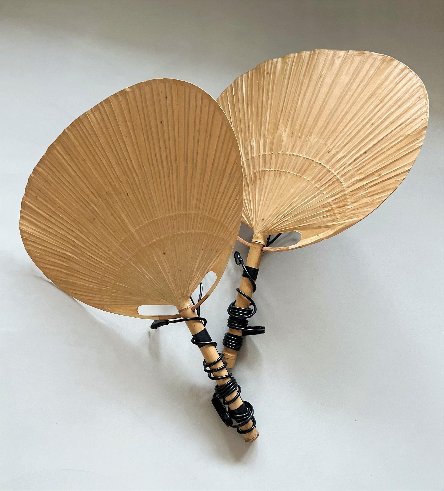 Zwei Stück große Vintage Uchiwa Fächerlampen mit Metallhalterung zum Aufhängen an der Wand.
Entworfen von Ingo Maurer, Deutschland im Jahr 1973.
Alle Fächer sind aus Bambus und japanischem Reispapier handgefertigt.
Die Lampen sind mit originalen