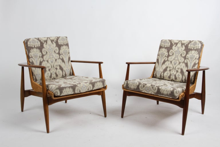 Rare pair of Lawrence Peabody's sculptural model 1806 / 917 chairs in solid walnut, design made by Richardson / Nemschoff in the early 1960s. Has unique wraparound arm design, that cradles a woven basket shell. This vintage example is in excellent