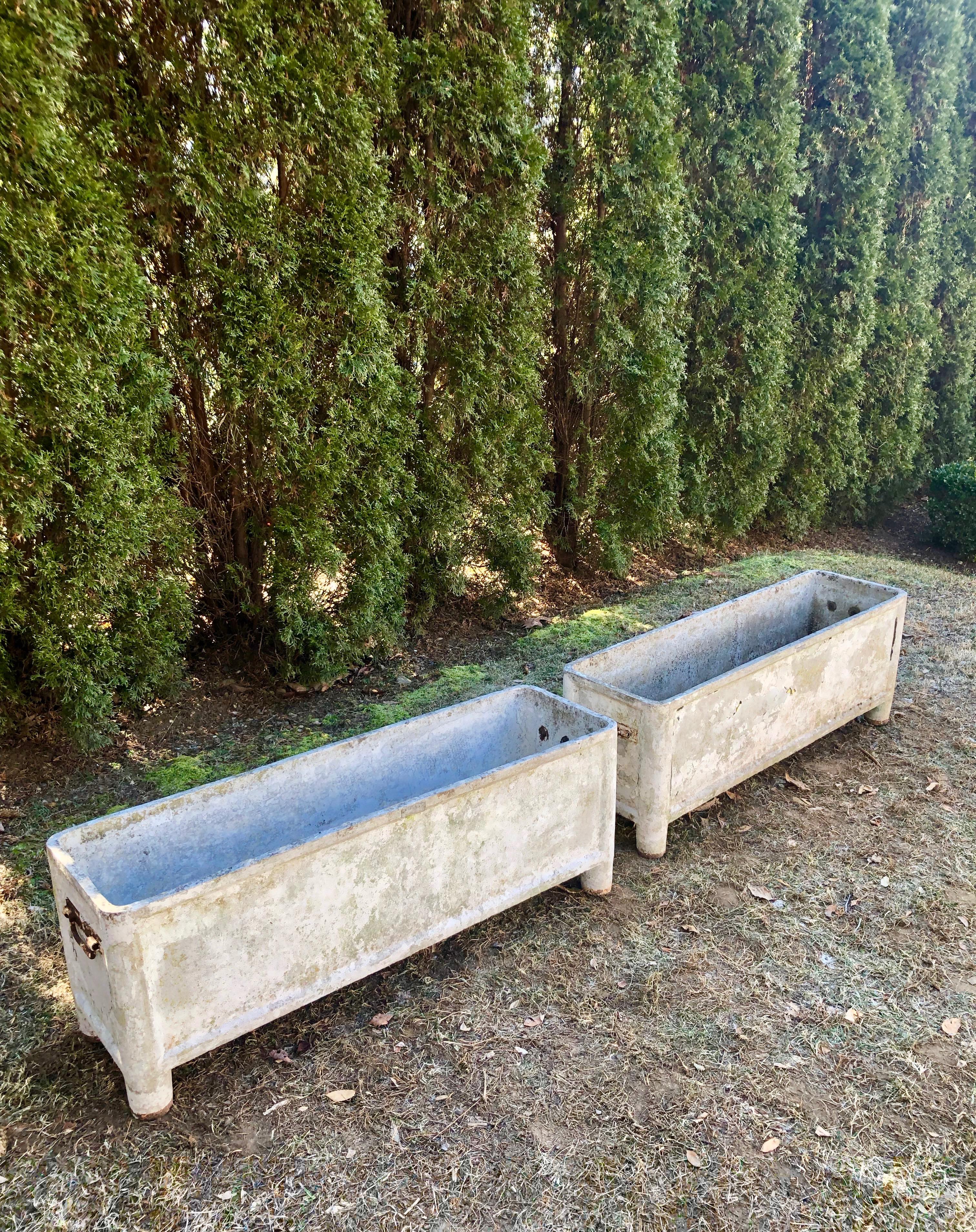 We see pieces by the famous French maker, Chanal, from time to time, but never a pair of such long jardinieres. In an exceptional weathered and greening surface with traces of crusty white paint (and a bit of yellow that easily flakes off), each