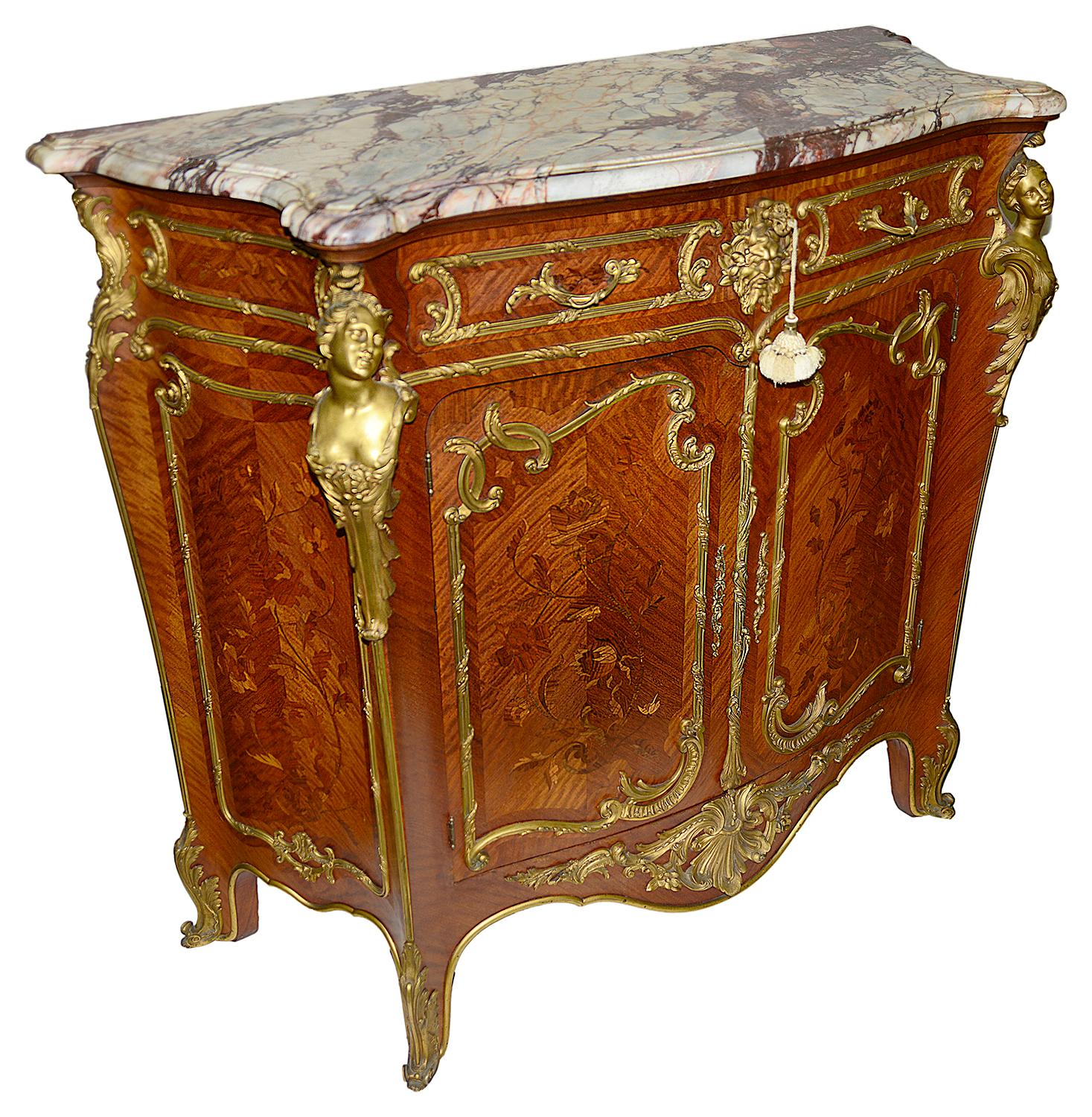 A superb and rare pair of Louis XV style ormolu-mounted side cabinets having the original breche marble tops, wonderful marquetry inlaid panels to the doors and sides. Scrolling ormolu mounts, mythical masks to the drawer fronts and carriatide