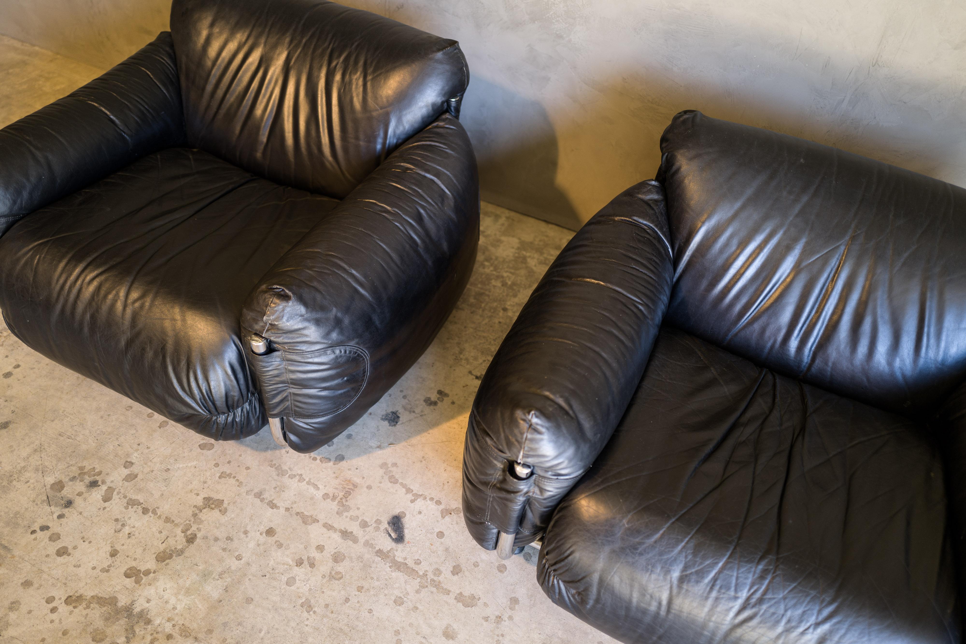 Vintage pair of lounge chairs designed by G. Munari for Poltrona Munari, 1970s. Original black leather upholstery with light patina and wear. Extremely comfortable. Original makers mark on the underside of the chairs.
