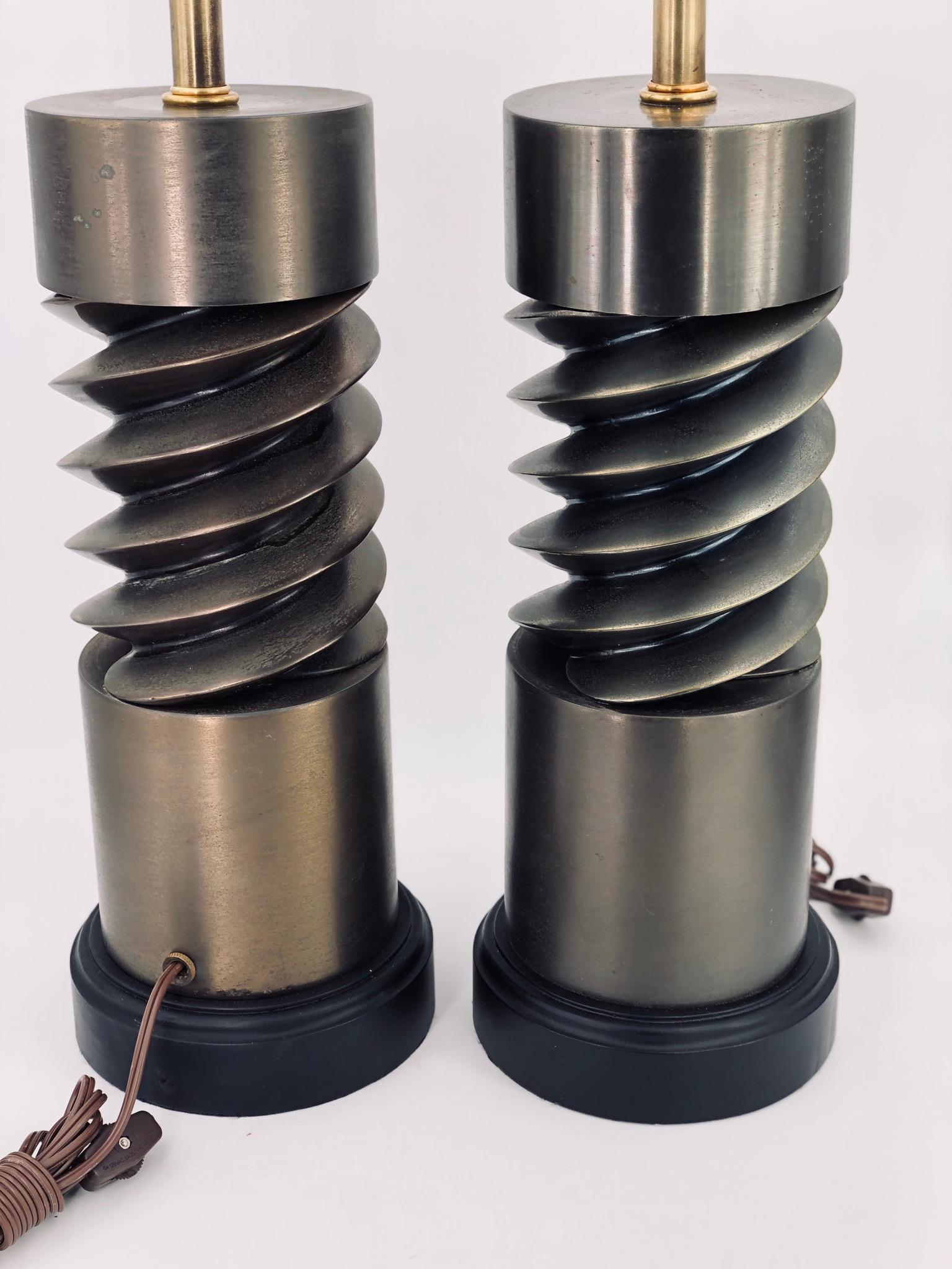 A rare pair of incredible machine age table lamps, twisted lamps in cast metal bronze finish patination, sitting on black wood painted bases, freshly rewired lamps shades are not included, each malm its 21