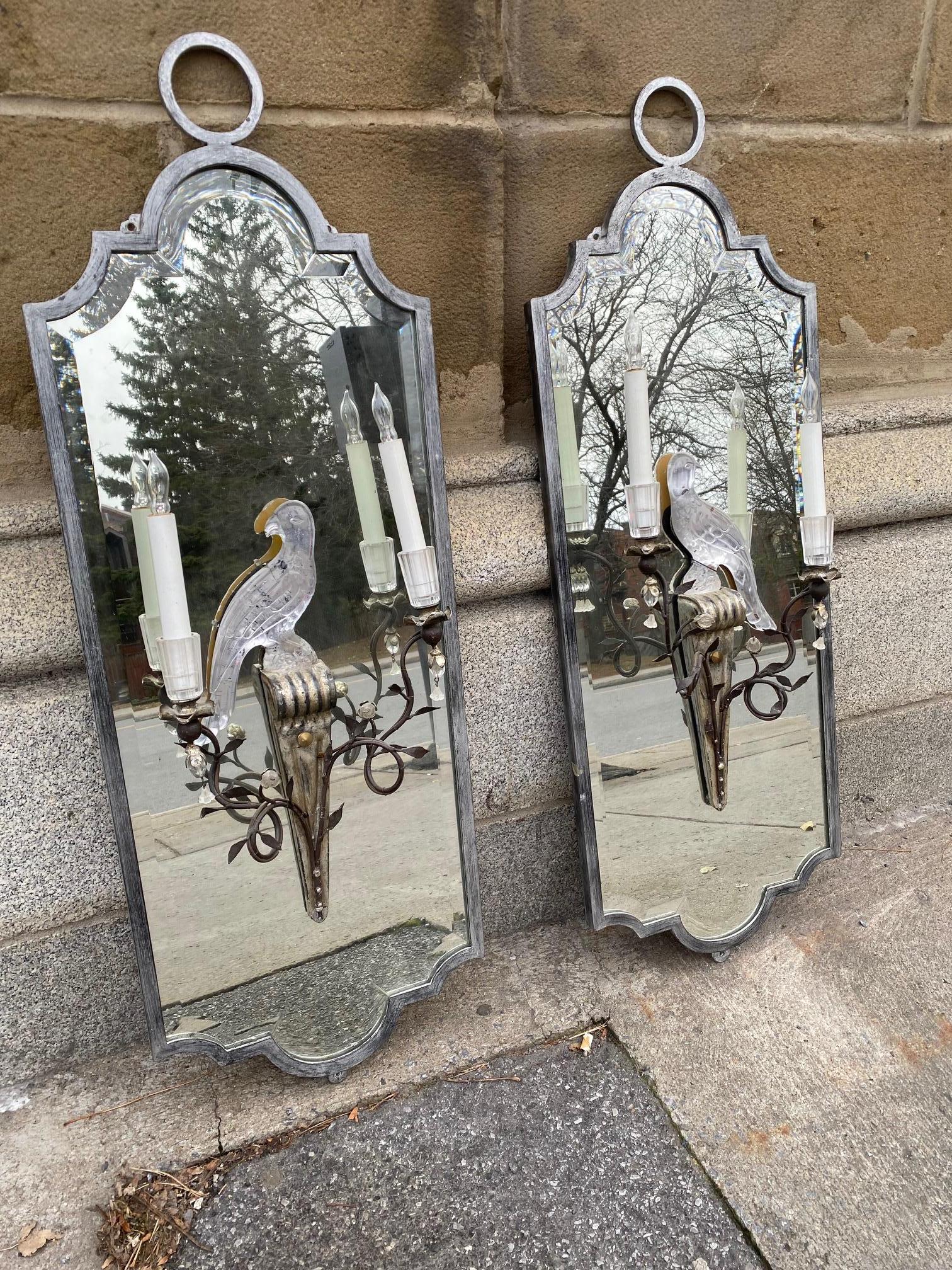 Rare Pair of Maison Baguès   parrot girandoles  mirrors fitted with typical moulded and etched glass parrot sconce figures.Shaped beveled mirrored glass set in silvered iron frames.
