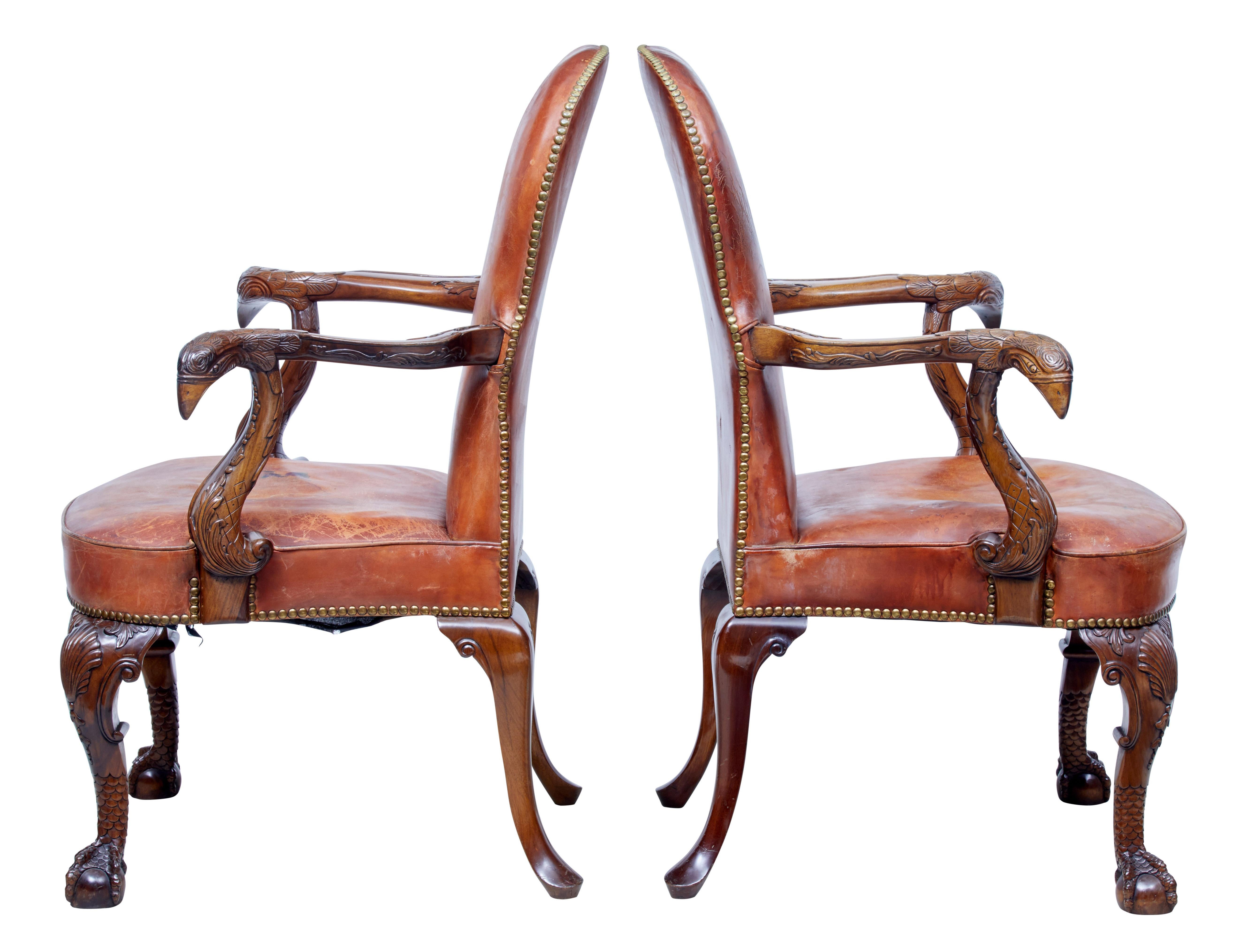 Rare fine quality English made mahogany armchairs, circa 1950.

Tan leather upholstery, carved open arms with swags and a possible peacock head. Standing on carved front legs with shell on the knee and a scaled ball and claw foot. Back legs