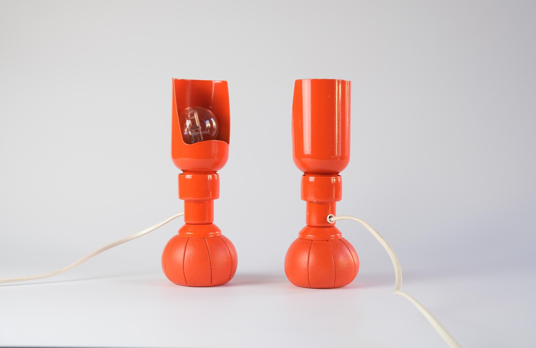 For sale are a pair of iconic and extremely rare orange 600P table lamps by GINO SARFATTI, designed in 1966 and produced by Arteluce of Italy.

Thanks to their lead-filled weighted pouch bases, the lamps can be placed at any angle and the reflector