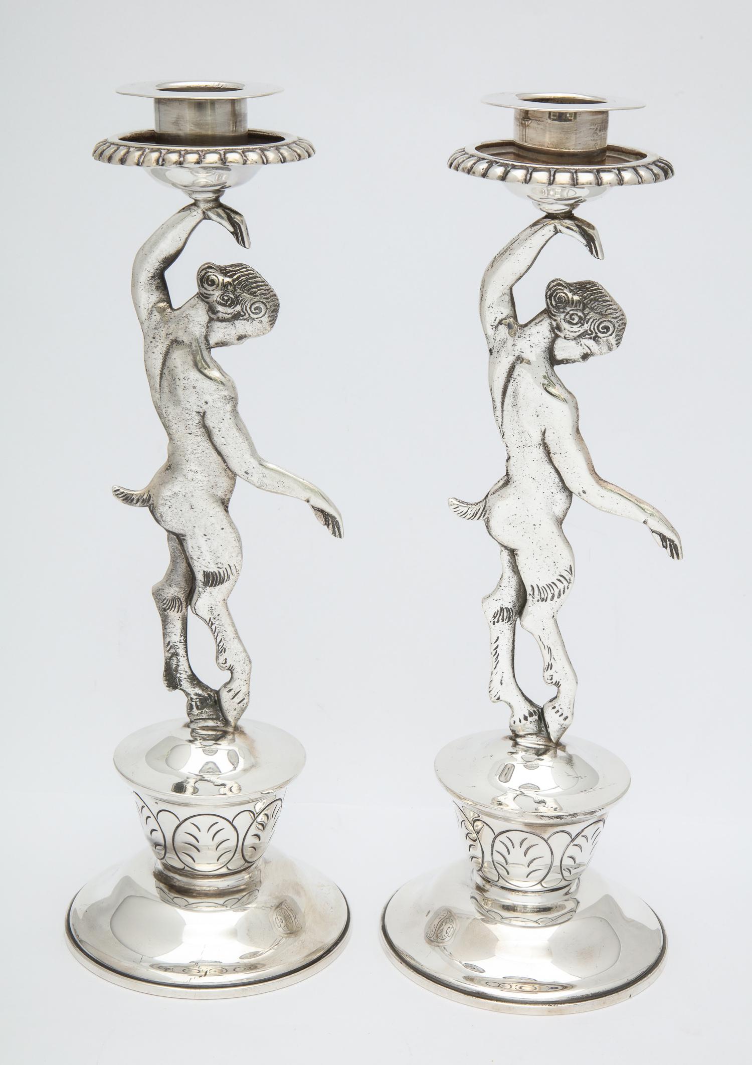 Rare pair of midcentury Mexican, sterling silver, satyr-form candlesticks, Mexico, circa 1950s, Conquistador Silver Company - makers. The stem of each candlestick is a full-bodied satyr, one side of each candlestick showing the satyr's front side;