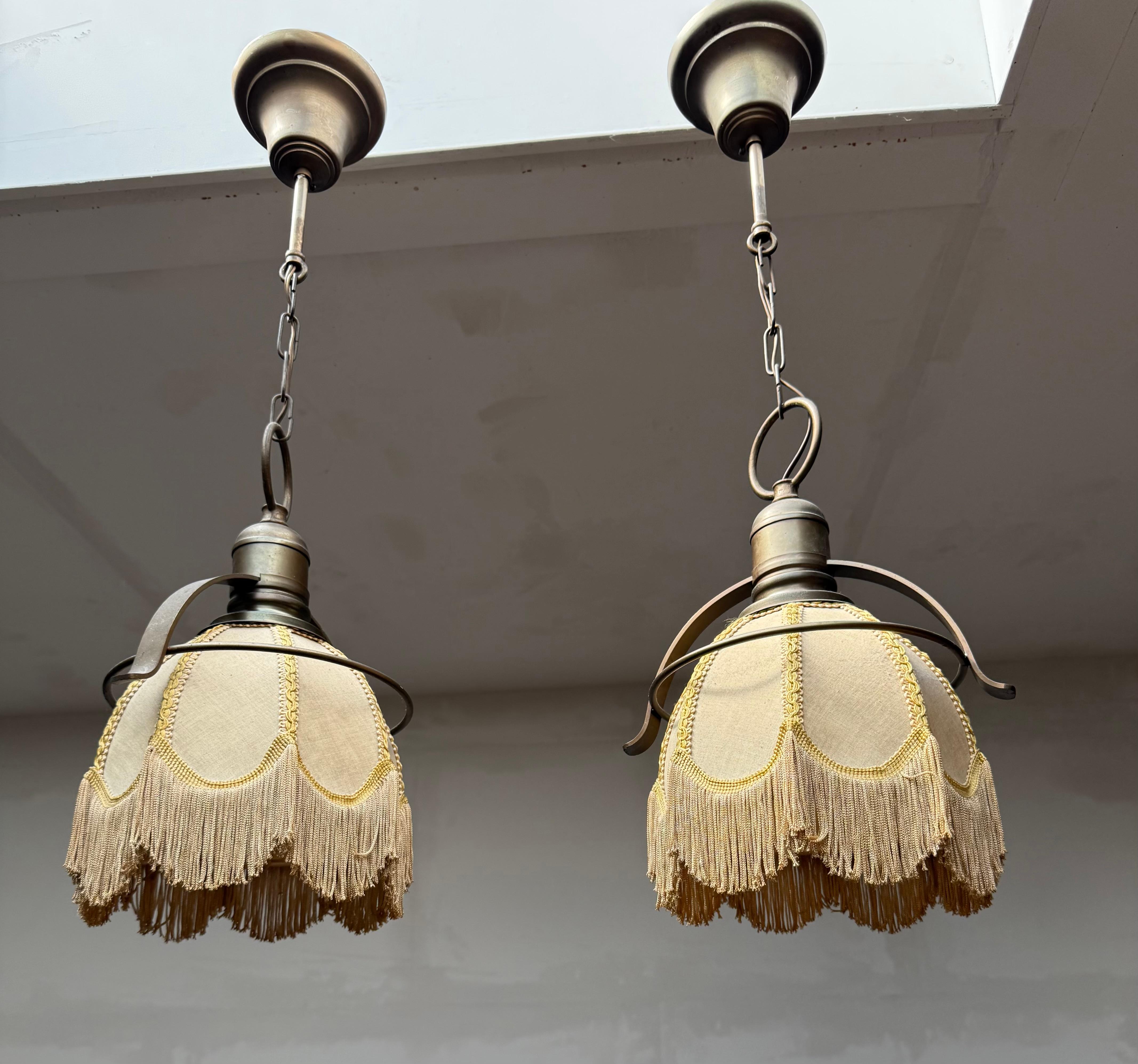 Pair of Midcentury cafe bar pendant lights with fabric shades, 1950.

A rare and elegant pair of midcentury pendant lamps from the 1950s, featuring their original brass frames and canopies( height-adjustable) and chains. The fabric shades are