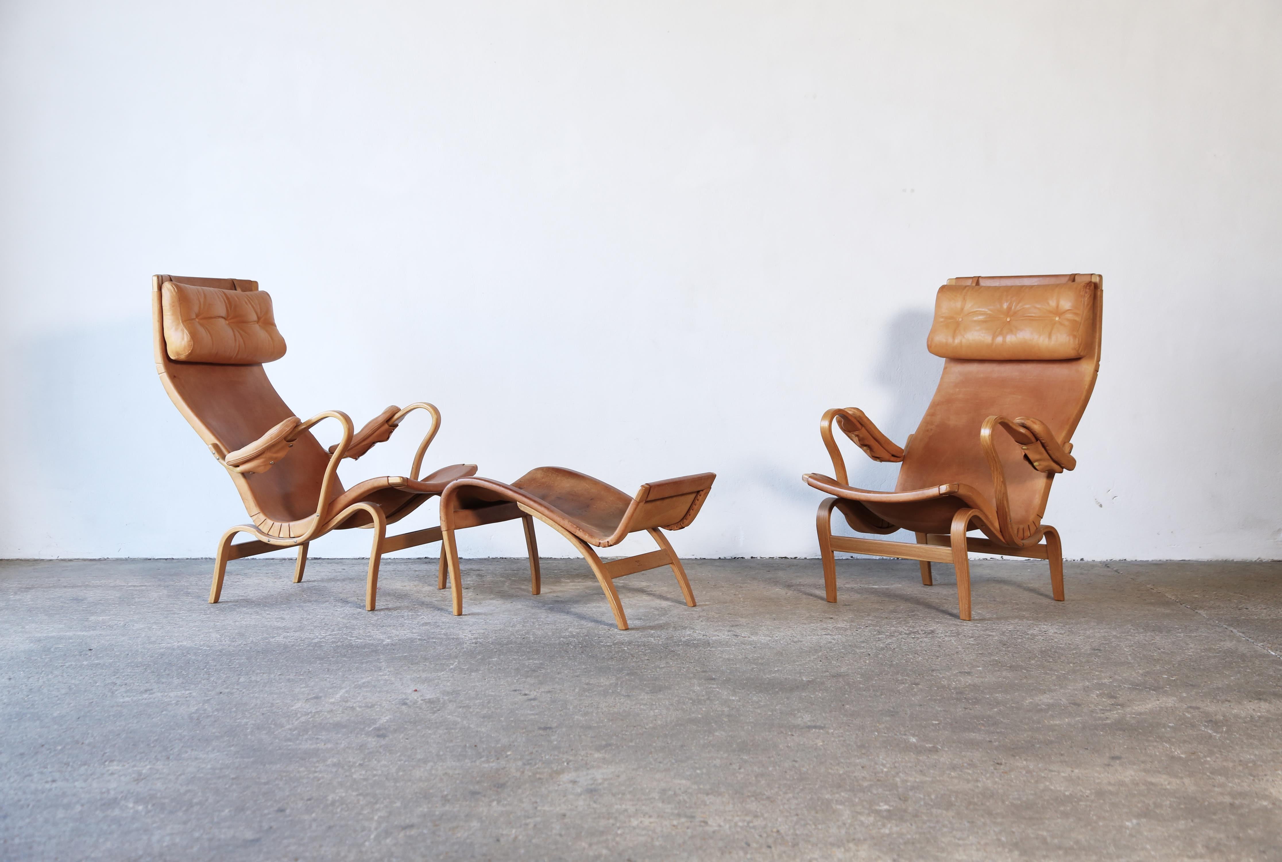 A very rare pair of Pernilla chairs and ottoman by Bruno Mathsson, for Karl Mathsson, Värnamo, Sweden, 1960s.  Beech frames and original leather seats.  Rarely found in such good condition.   The chairs show only minor marks.  Ottoman leather shows