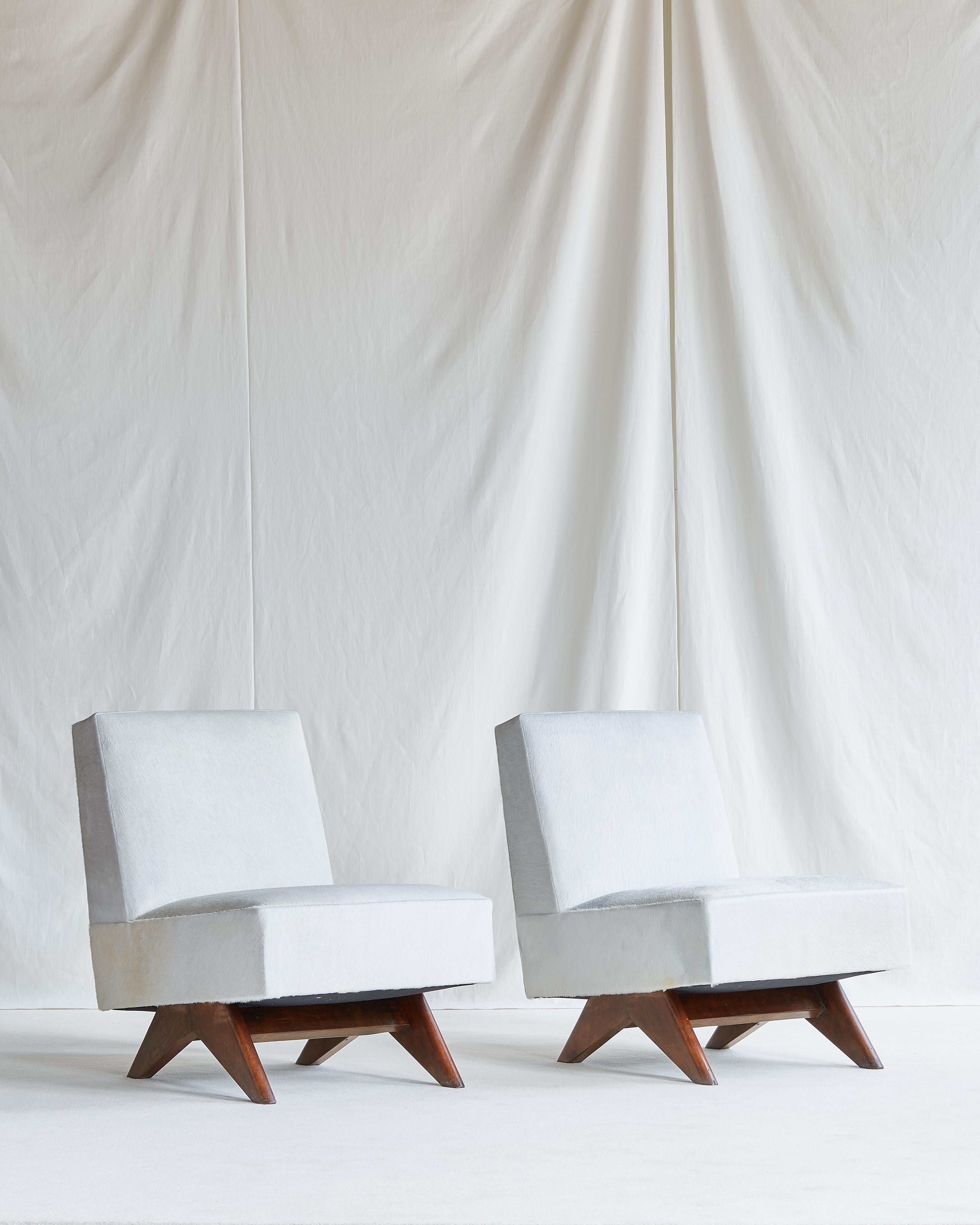 Rare pair of Pierre Jeanneret low upholstered lounge chairs with low inverted compass type leg.

High Court of Chandigarh c. 1955-1956

Upholstered in Italian sheared white cow hide. Seat interior has been completely refurbished, all springs