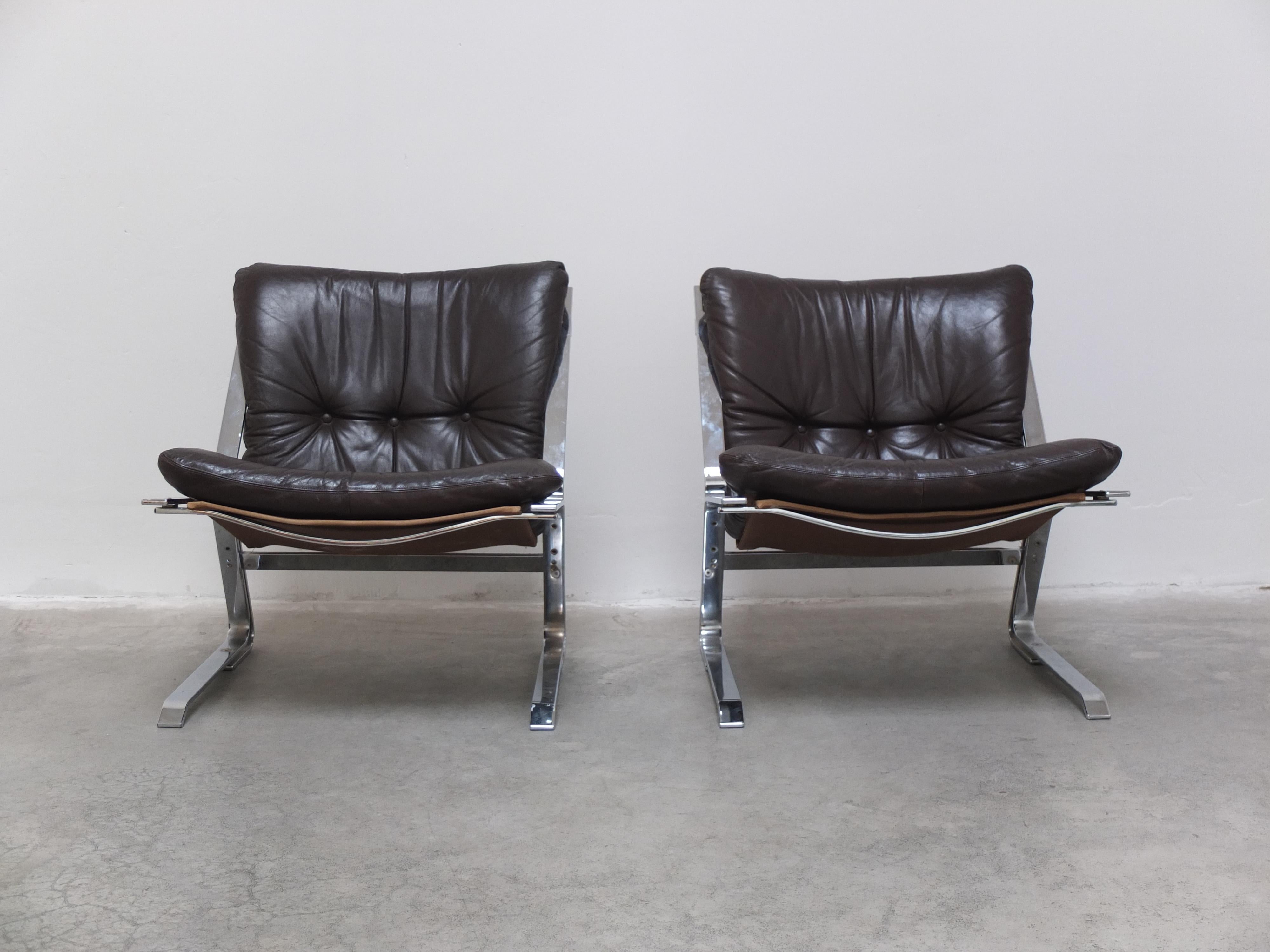Magnificent pair of easy chairs designed by Elsa & Nordahl Solheim for Rybo Rykken and Co. in Norway during the 1960s. A very interesting design with frames made of chromed flat steel combined with the original and very soft dark brown leather