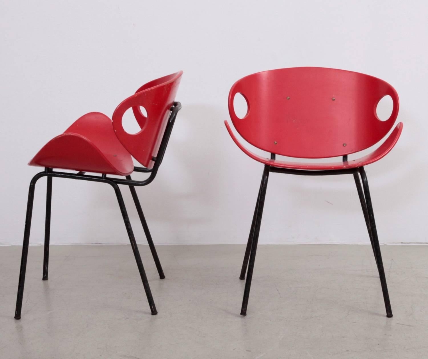 Rare pair of 1950s chairs by Olof Kettunen for Merivaara, Finland. The chairs are made of four black metal legs and a curved plywood seat and back. The chairs in original red color are really rare. A simple and elegant design, labelled by J.