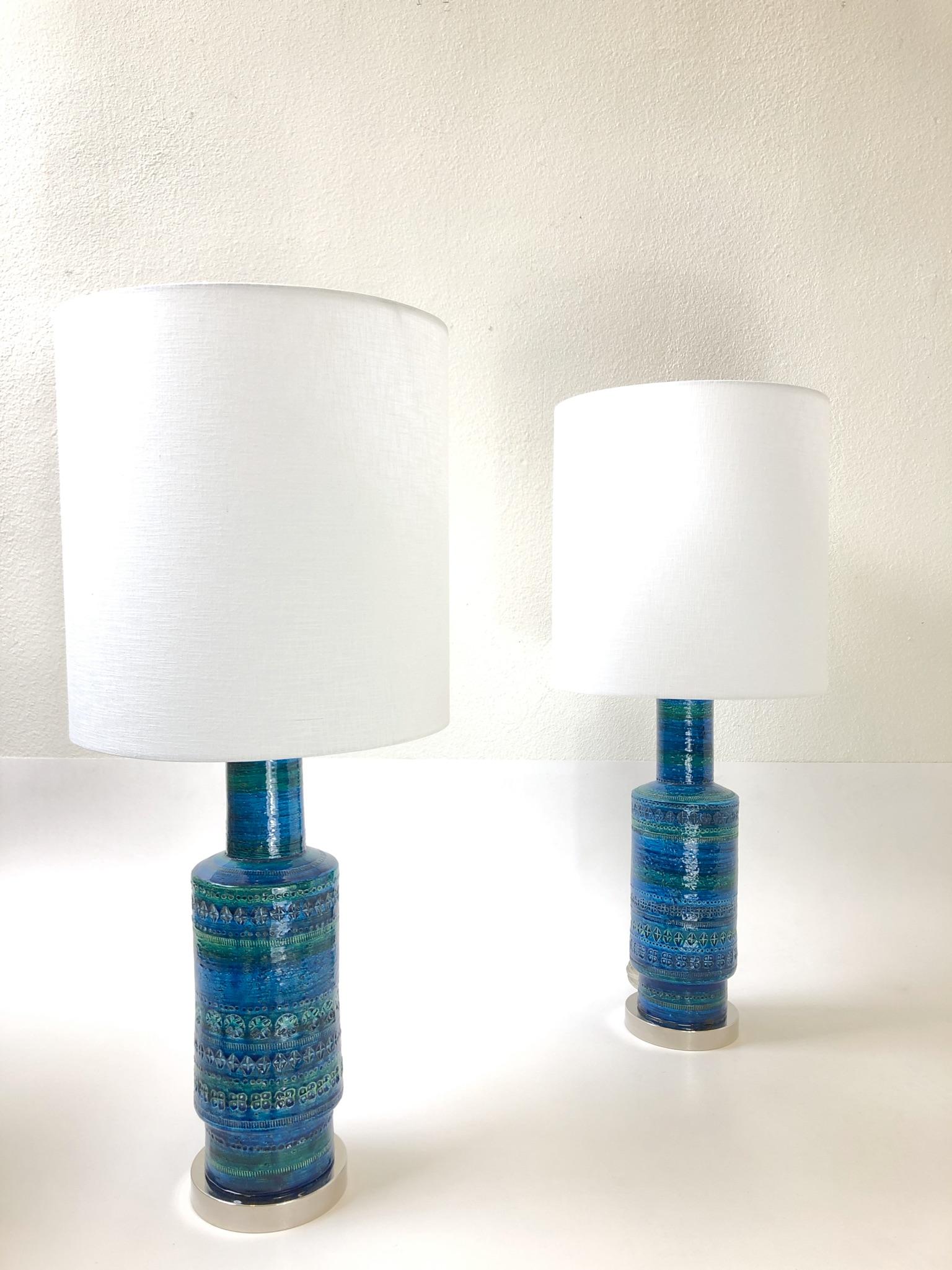 A rare pair of Italian ceramic Rimini blue table lamps design by Aldo Londi for Bitossi in the 1960s. The lamps are marked made in Italy inside the ceramic vase. The lamps have been newly rewired with new polish nickel hardware and new white linen