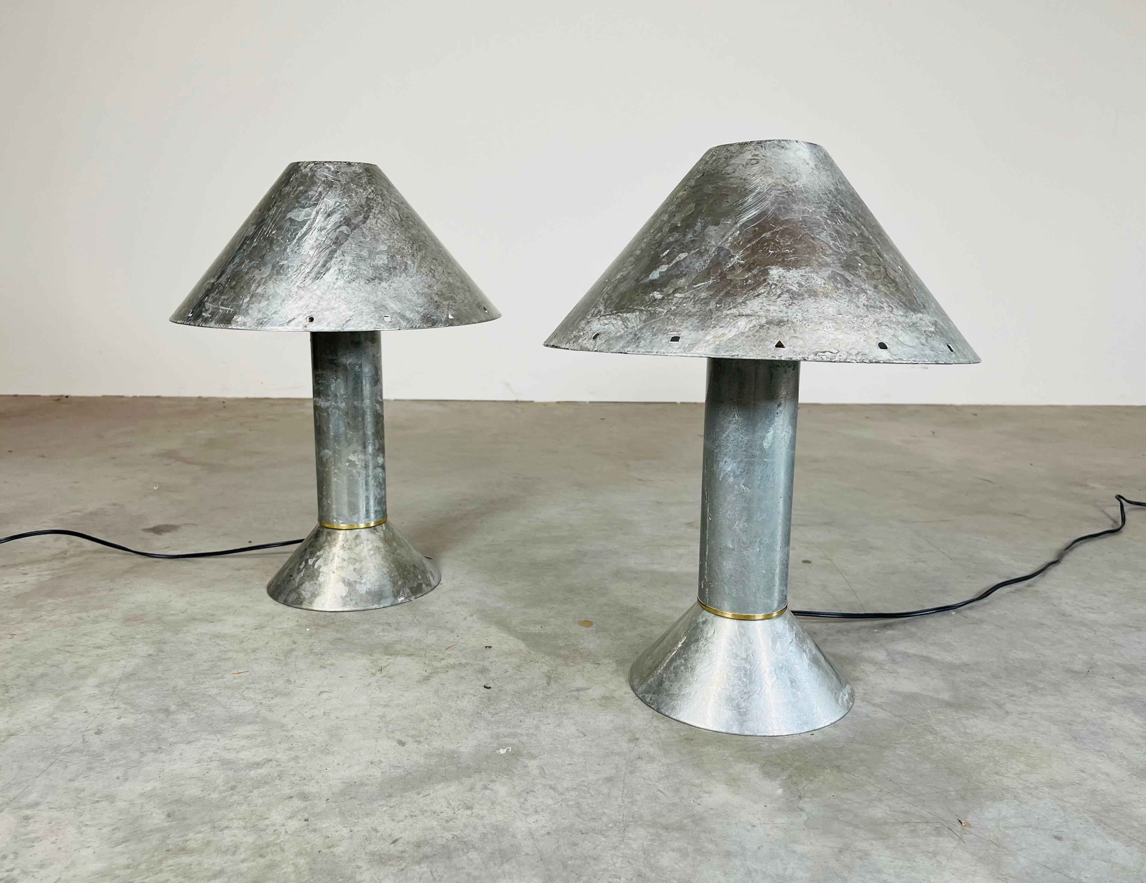 Cette paire de lampes de table de style industriel Ron Rezek en zinc trempé à la main est dotée d'un abat-jour amovible surmontant un abat-jour en émail blanc. Conçu par le légendaire designer d'éclairage industriel Ron Rezek, né le 31 octobre 1946