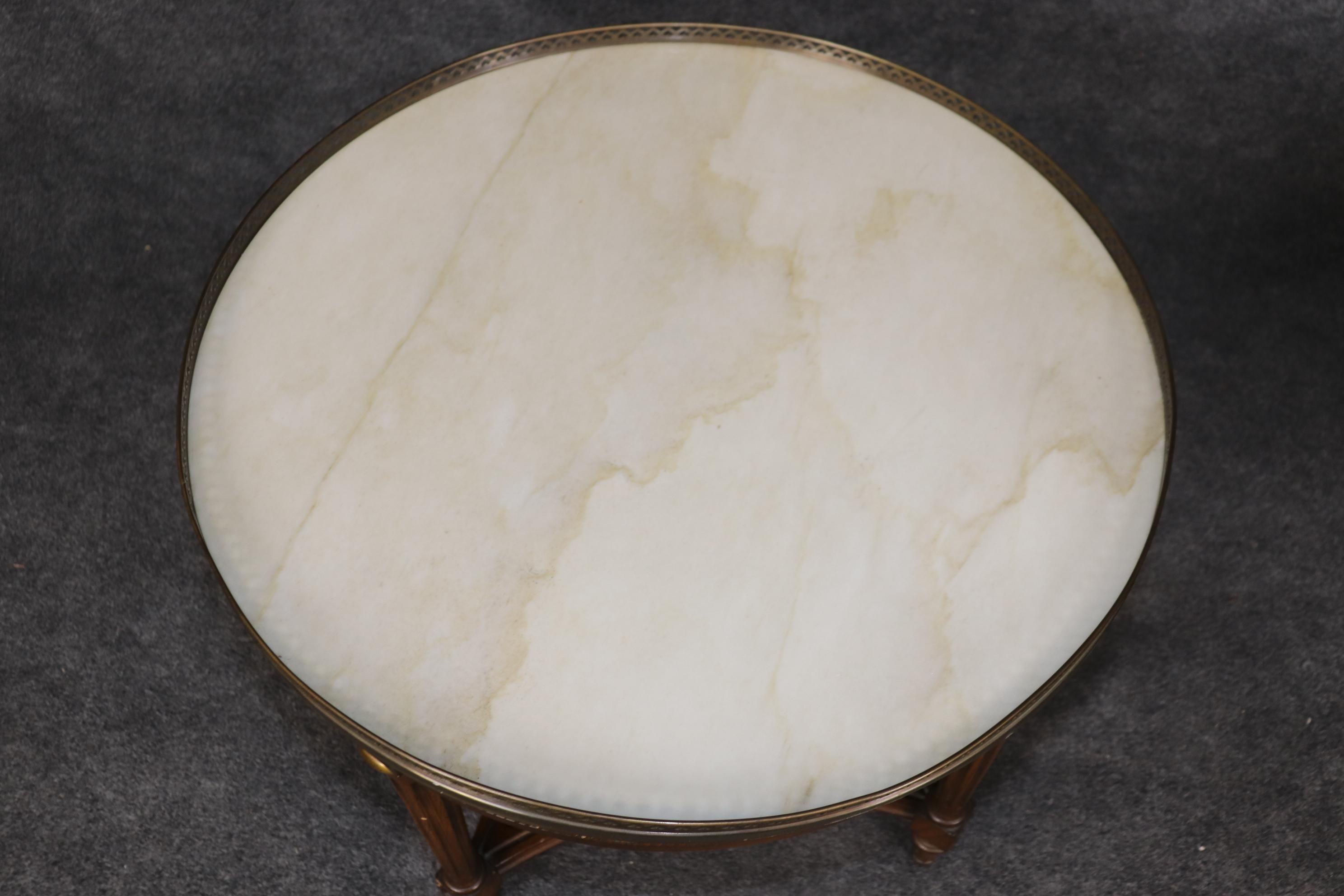 This is a spectacular pair of French-made Directoire style or Louis XVI style gueridons or end tables. They are absolutely gorgeous! Look at the round walnut frames with beautiful brass ormolu and brass galleries surrounding the white marble tops.