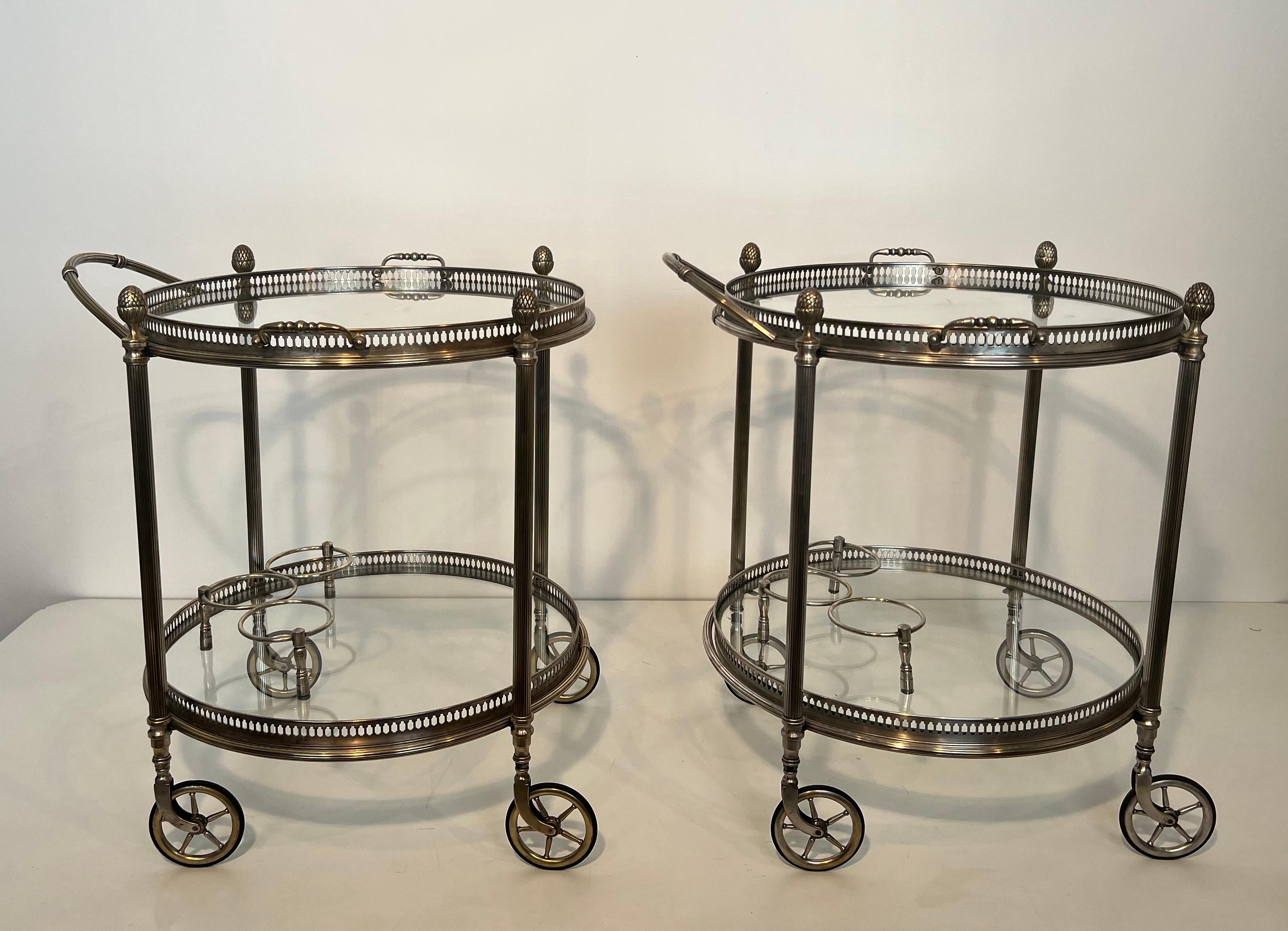 This very nice and rare pair of  neoclassical Style Round Bar Carts is Made of Silvered Brass with removable trays. This is a French work by Maison Bagués. Circa 1940