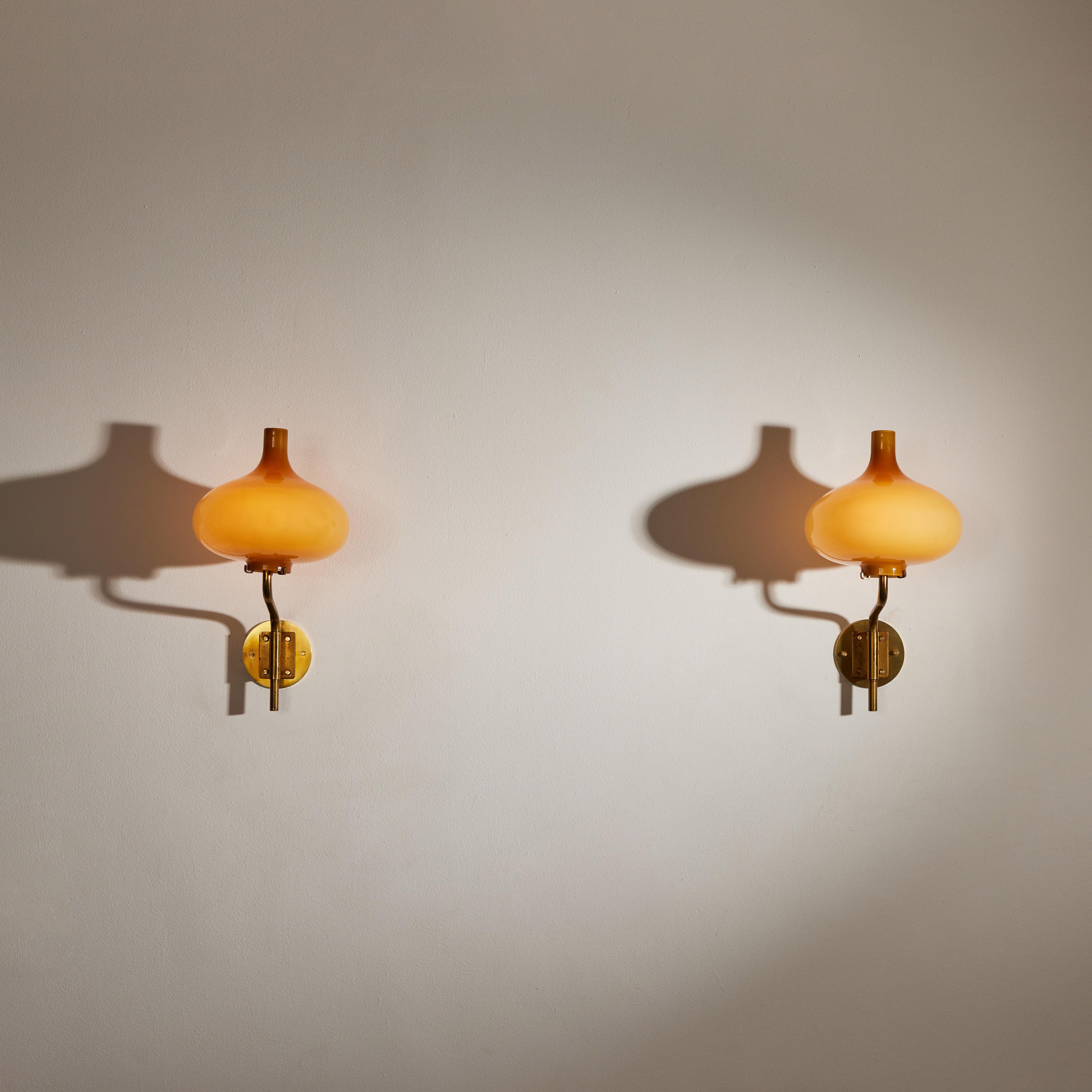 Rare pair of sconces by Annig Sarian. Manufactured in Adrasteia, Italy, 1958. Brass, blown glass diffuser. Wired for U.S. standards. Custom brass backplate. Each light takes one E14 European candelabra 40w maximum bulb. Bulbs provided as a one time