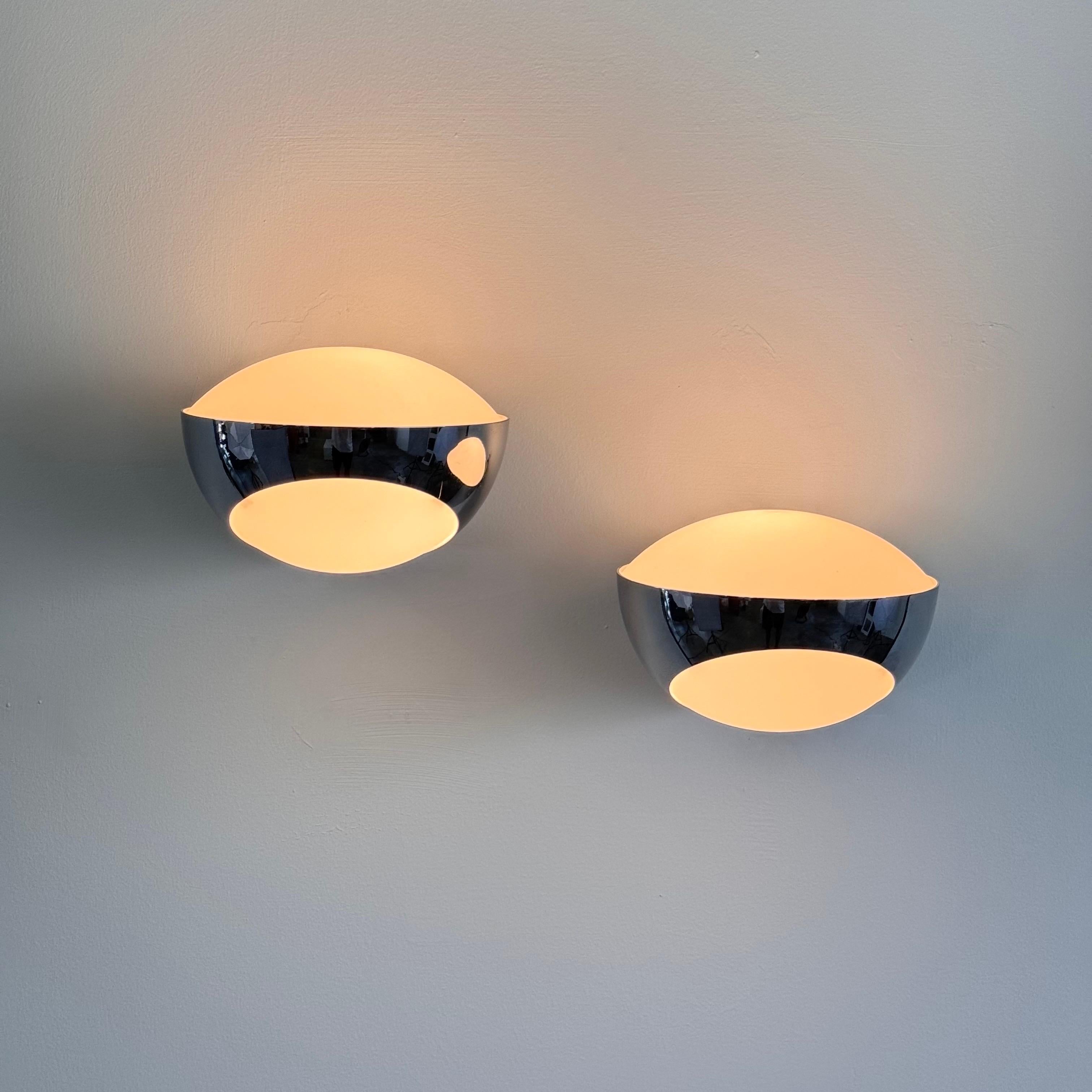 Un raro par de apliques niquelados diseñados por Max Ingrand para Fontana Arte, Model 1963/1. Fabricadas a finales de la década de 1960, estas elegantes piezas presentan una sofisticada combinación de latón niquelado y cristal opalino, mostrando la
