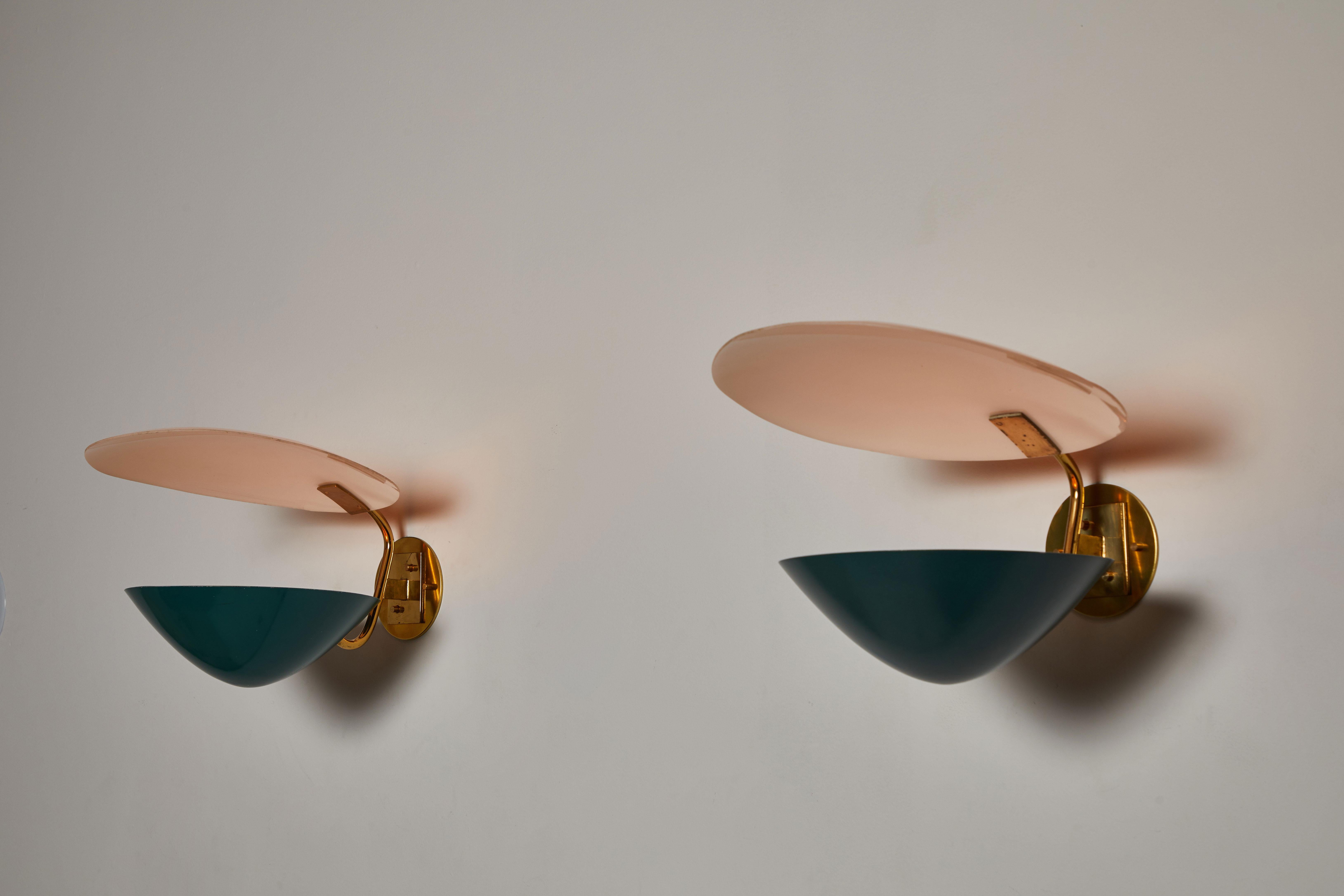 Rare pair of sconces by Stilnovo. Manufactured in Italy, circa 1950s. Enameled metal and brass. Rewired for US junction boxes. Custom brass backplate. Each sconce takes one E27 40w maximum bulb. Retains original manufacturer's label.