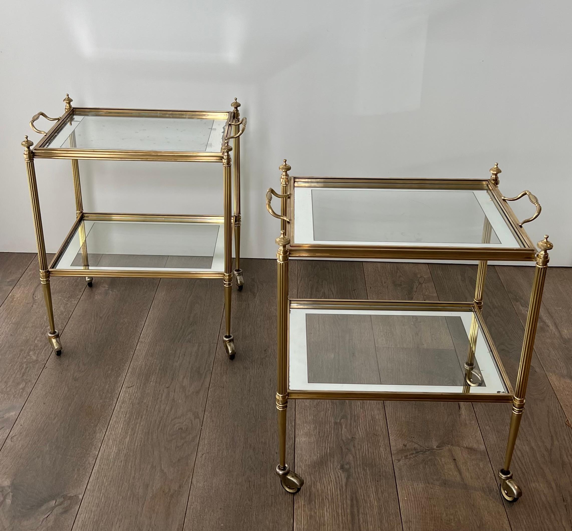 This beautiful and rare pair of side tables is made of brass with glass trays. The side tablescan be used as bar carts with removable upper trays. Clear glass trays are surrounded by a silvered line. This is a French work by Maison Jansen. Circa 1940