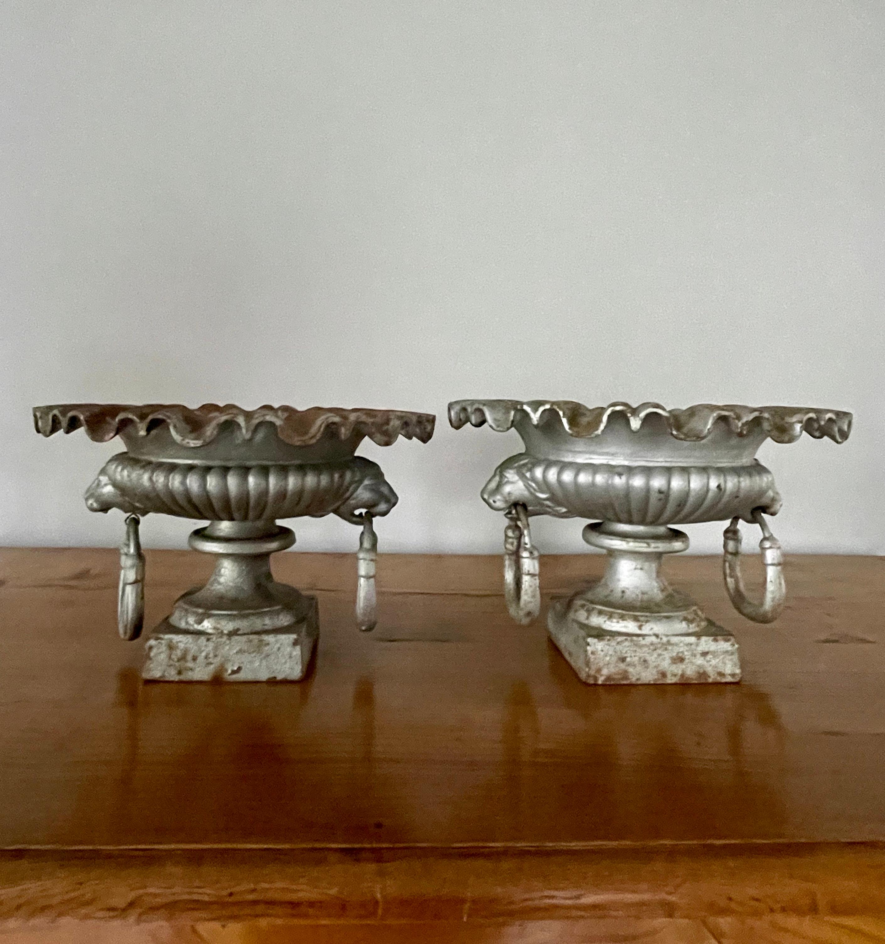 This style of urn is hardly ever found and they are just wonderful! With their heavily-ruffled rims, semi-lobed bodies, and lion-head ring handles, they are perfect for a stunning flower-filled tabletop display inside or out. Dating to the 1880s but