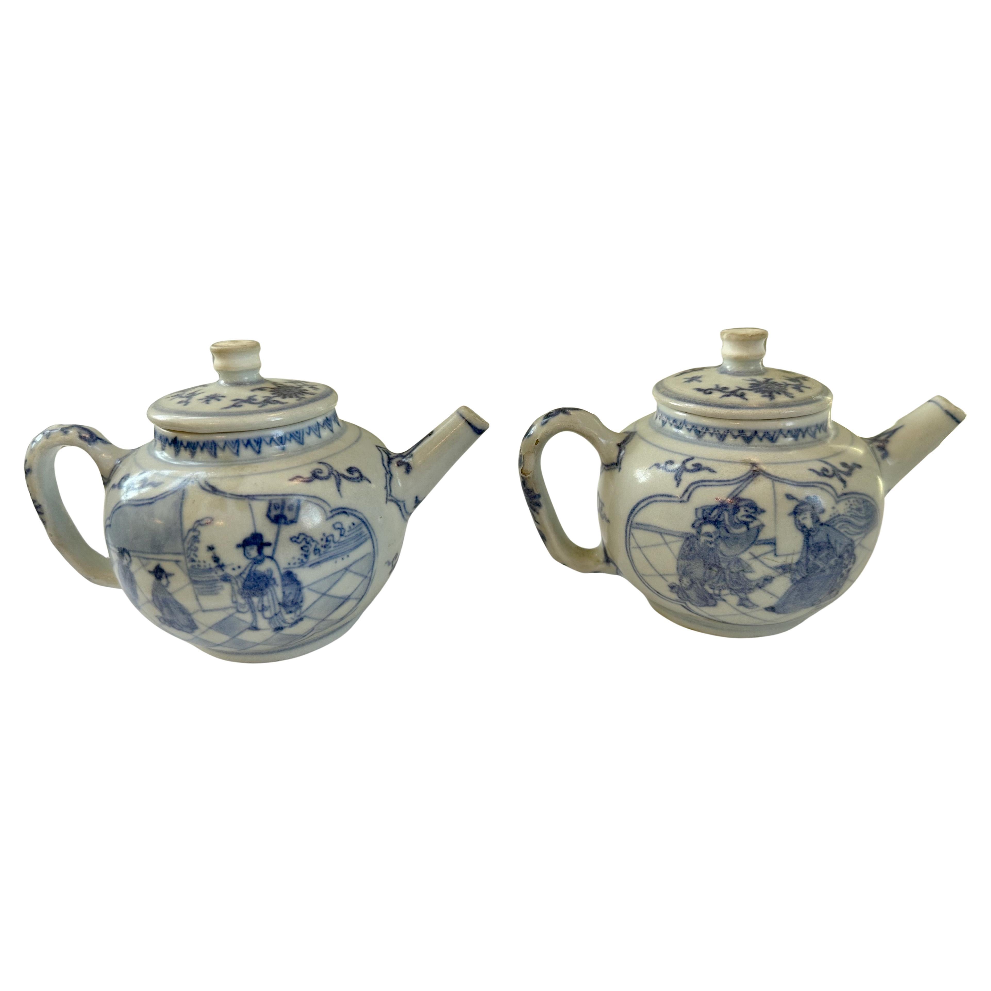 Rare paire de théières globulaires bleues et blanches avec couvercles de la Collection Whiting, peintes d'une variété de scènes. 

Les théières ont des cols courts et droits et des becs cylindriques. Elles sont peintes dans un ton bleu doux avec des
