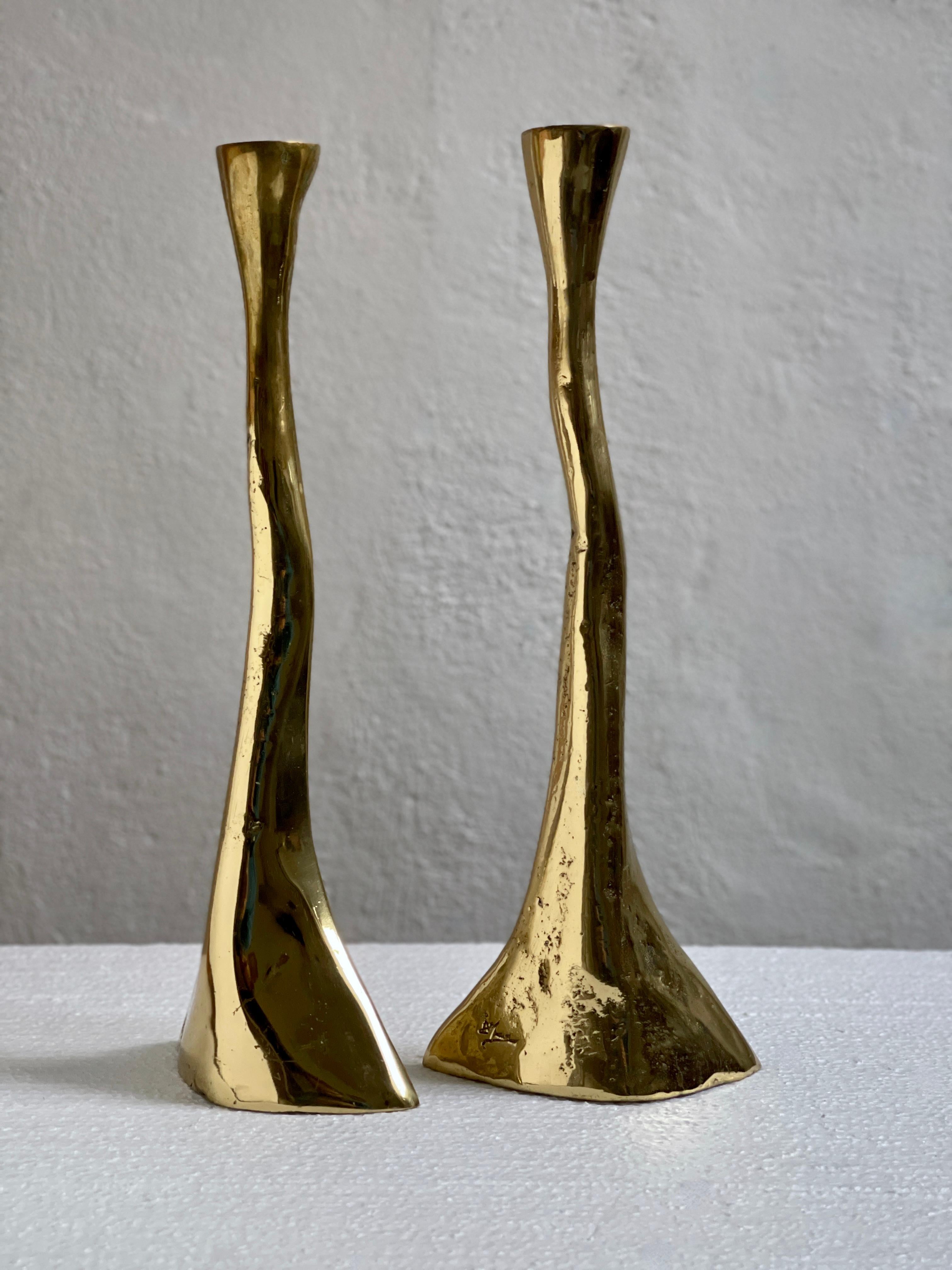 A rare pair of solid and heavy brass candlesticks from mid-20th century Denmark is a captivating testament to the fusion of craftsmanship and design inherent in the era's decorative arts.

The rustic  casting technique employed in their creation