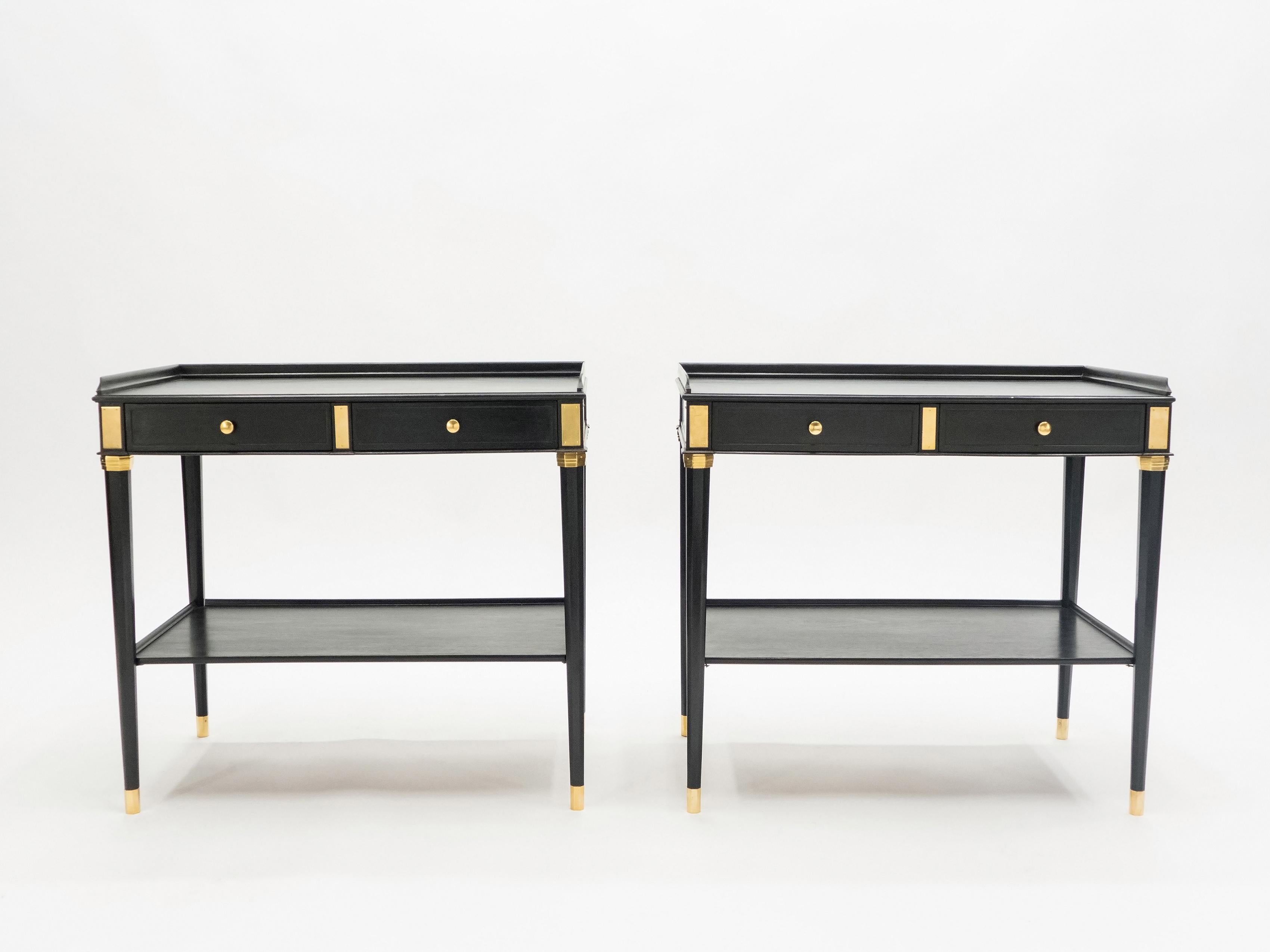 This rare pair of two-tier end tables or side tables by French house Maison Jansen was created in the early 1950s with black varnished mahogany wood, and brass details and accents. Typical and timeless French neoclassical style from Maison Jansen,