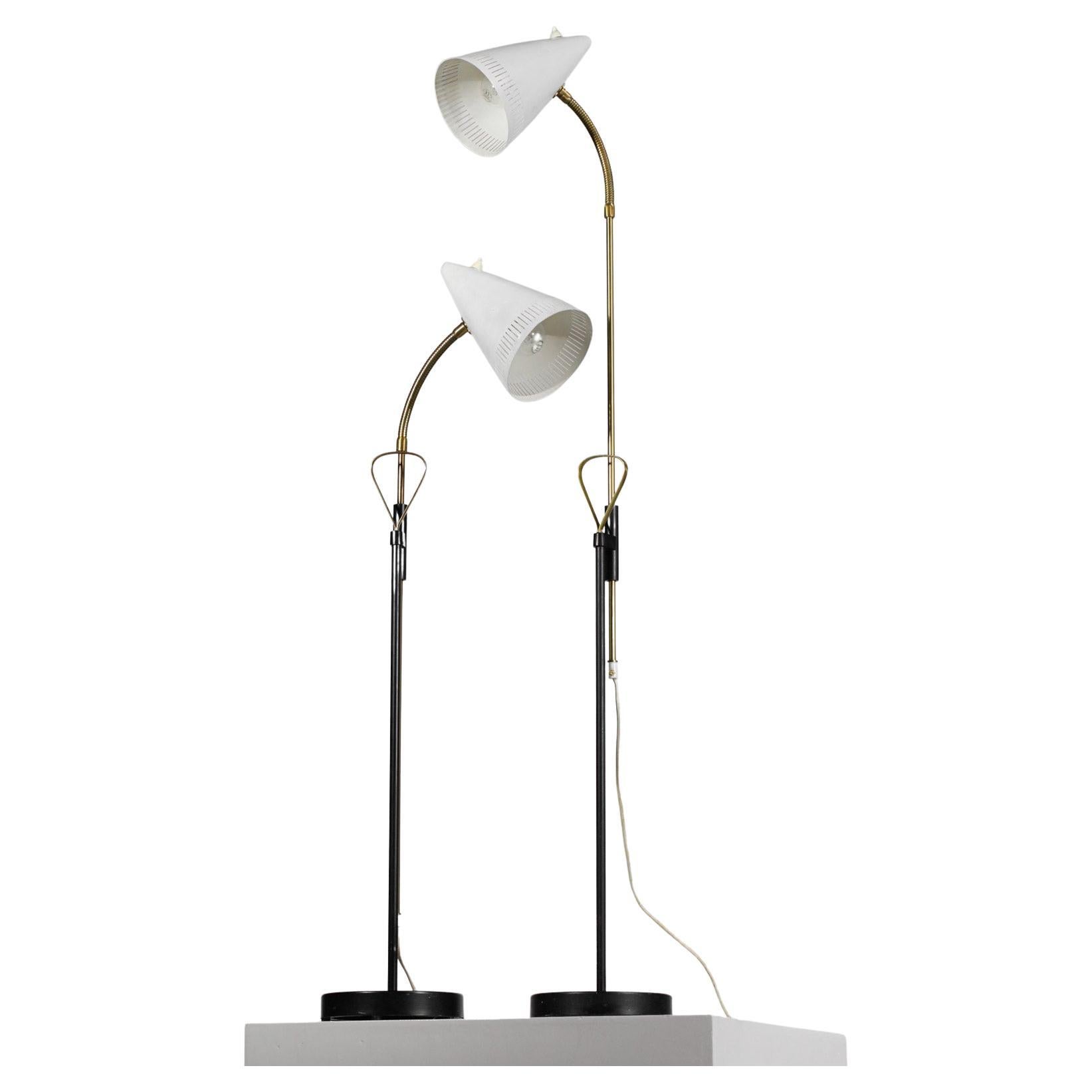 Pair of Scandinavian floor lamps by Swedish designer Falkenbergs Belysning from the 60s. Solid brass retractable and swivelling main stem, black and white lacquered metal base and shade, brass handle. Very nice vintage condition, original paint.