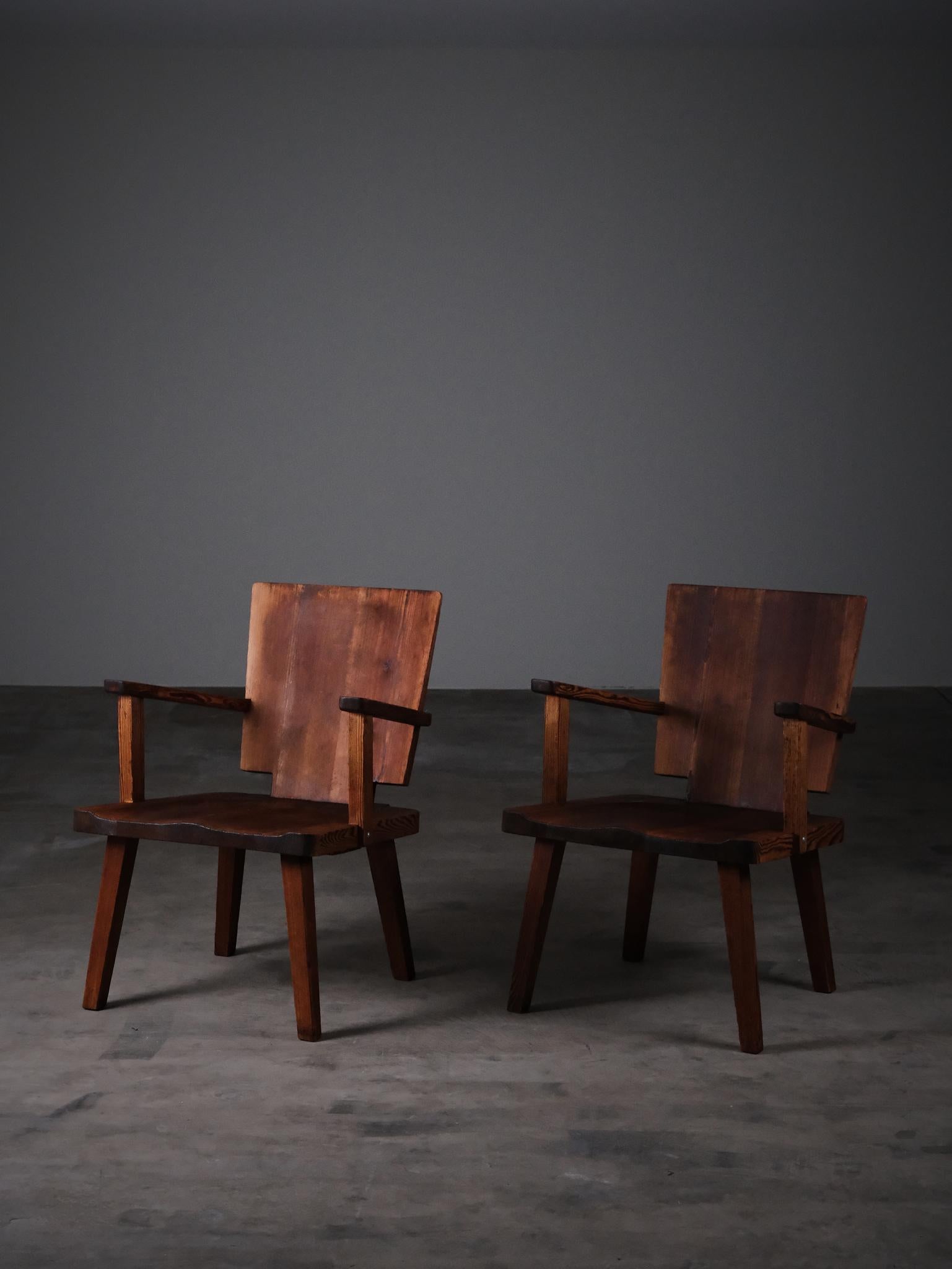 A rare and distinctive pair of armchairs crafted in Sweden during the 1930s, designed by an unknown maker.

Made from solid pine, these armchairs feature a rich, naturally aged patina, sculpted seats, and bold, brutalist backrests—hallmarks of the