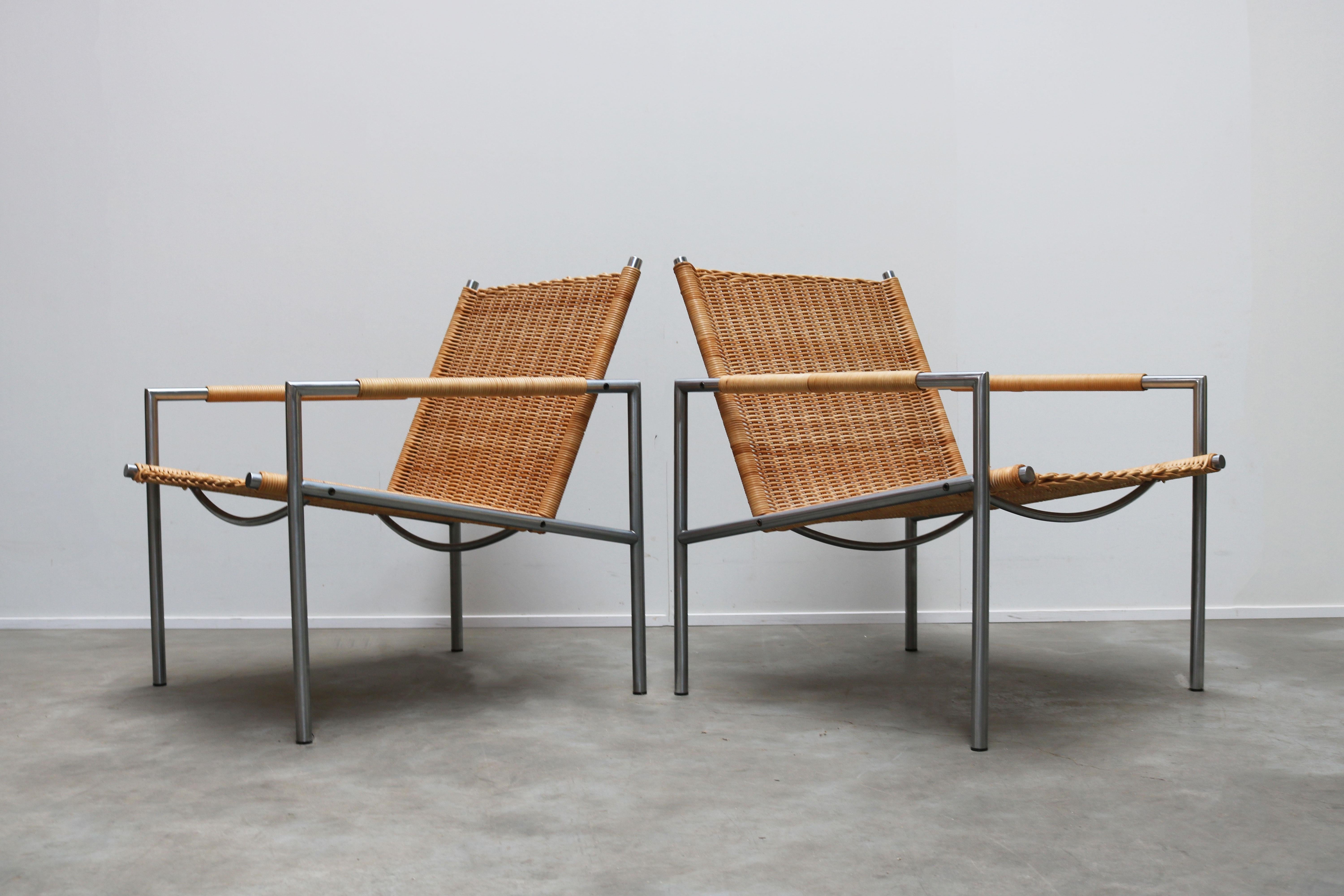 Magnificent pair of SZ01 Minimalist lounge chairs in rattan and chrome by Dutch Industrial designer: Martin Visser for T' Spectrum in 1960. The Minimalist tubular chrome frame in combination with the rattan armrests and rattan back/seat where