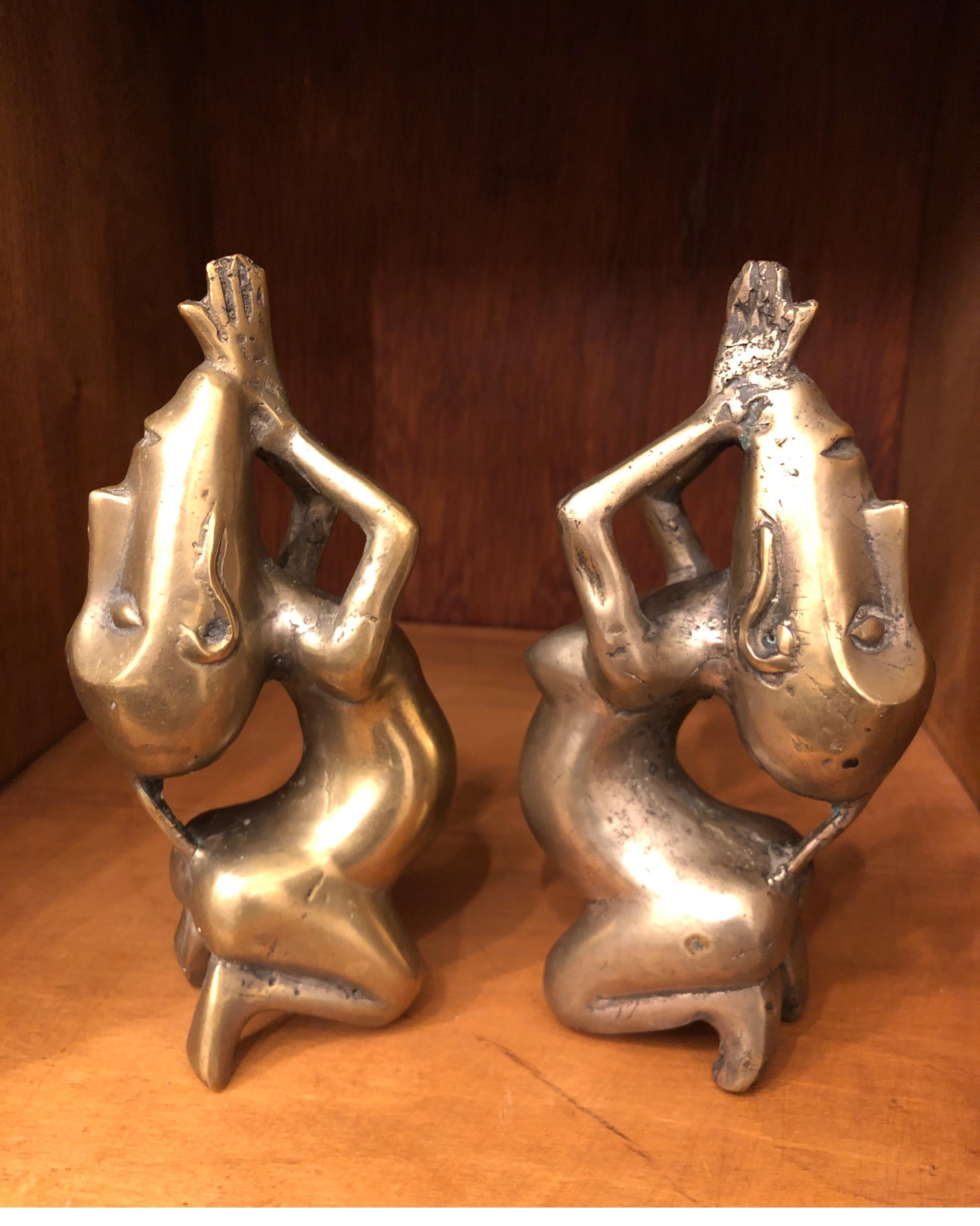 Unique pair of statues. Male and female made of solid brass. 
Elongated faces with hands clasped.

Natural patina.
