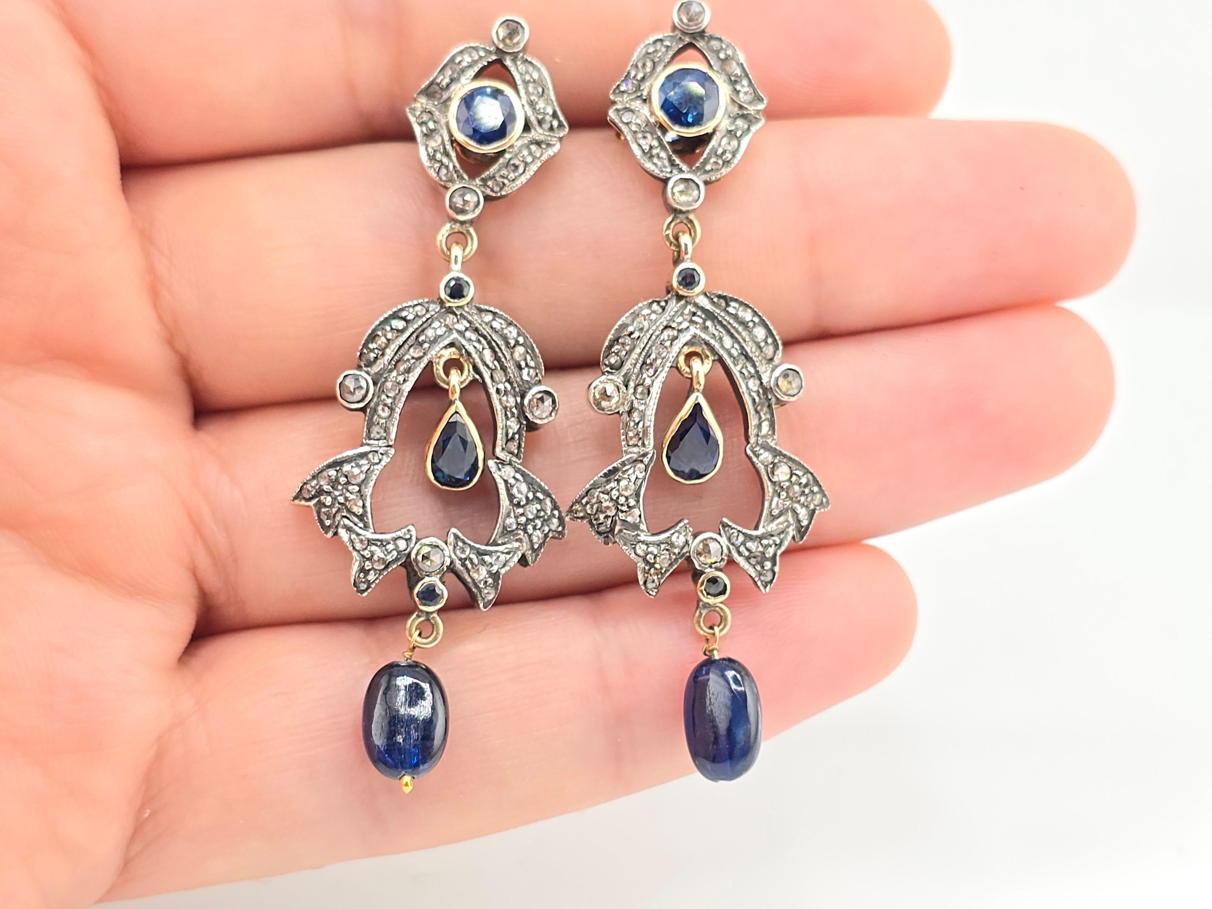 This is a gorgeous pair of diamond and sapphire, Victorian era earrings. There are diamond mine cuts all around the earrings, with beautiful, rich, vivid sapphires. The material I believe it is made out of 14 karat yellow gold and sterling silver.