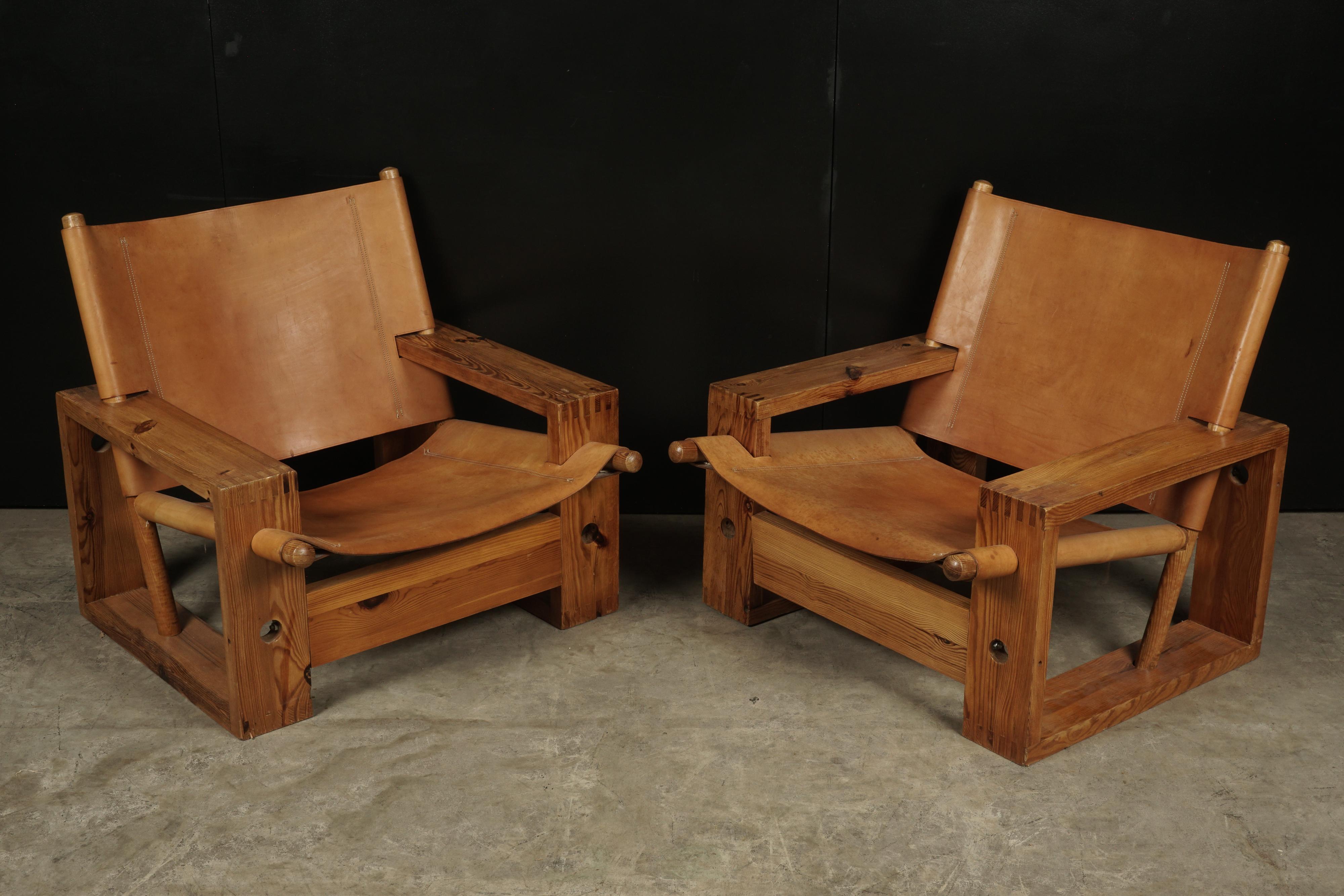 Rare pair of vintage dutch easy chairs designed by Ate Van Apeldoorn, 1970s. Solid pine construction with stretched cognac saddle leather.