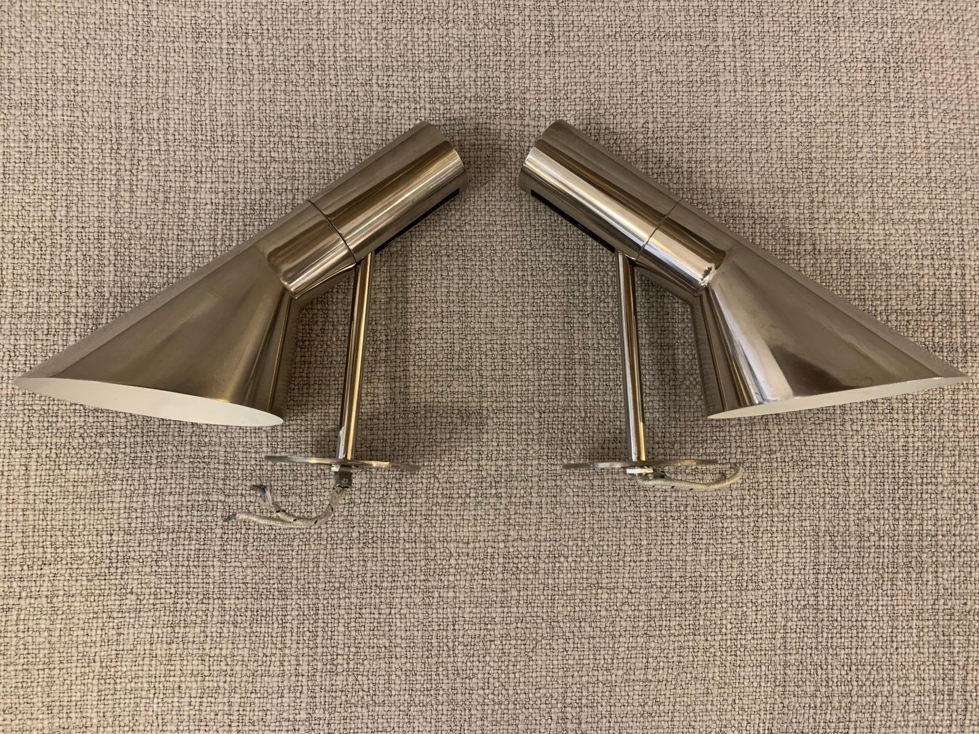 Beautiful pair of Arne Jacobsen AJ Wall / Visor lamps in rare nickel execution. 
Would make a wonderful set of bedside lamps. 
Lamps are executed with quality porcelain fittings and are individually marked with Louis Poulsen labels. 
Excellent all
