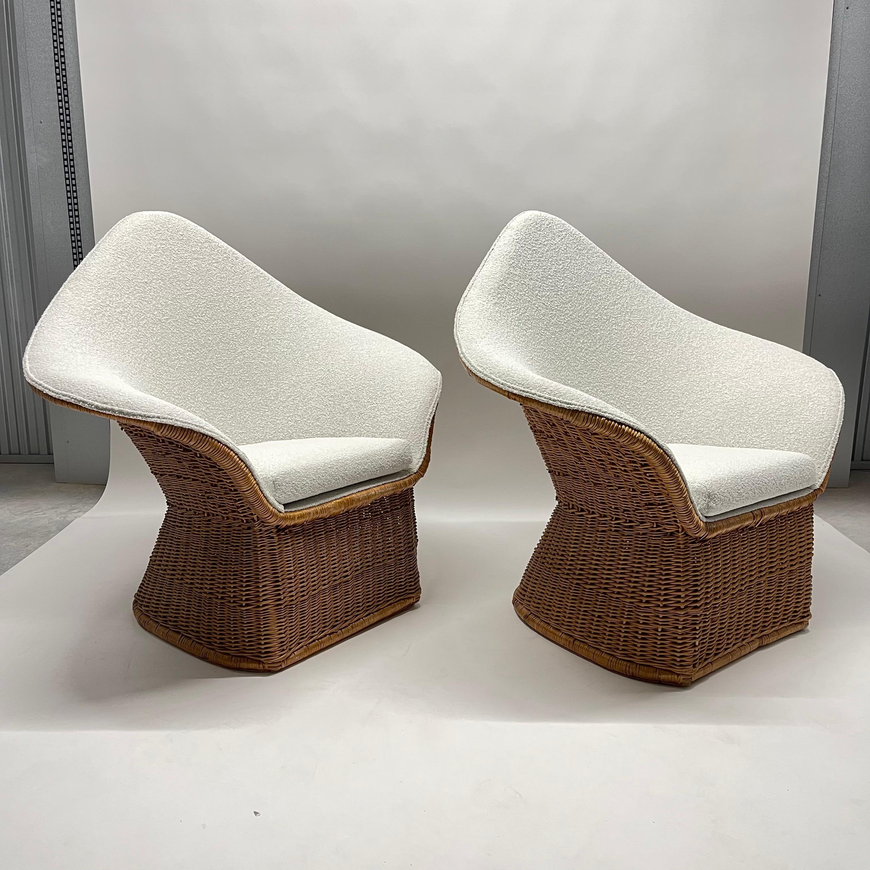 Rare pair of mid-century sculptural chairs rendered in a hand woven wicker and rattan frame newly upholstered in a creamy neutral textural bouclé in the style of Tito Agnoli, Italy, circa 1970s.