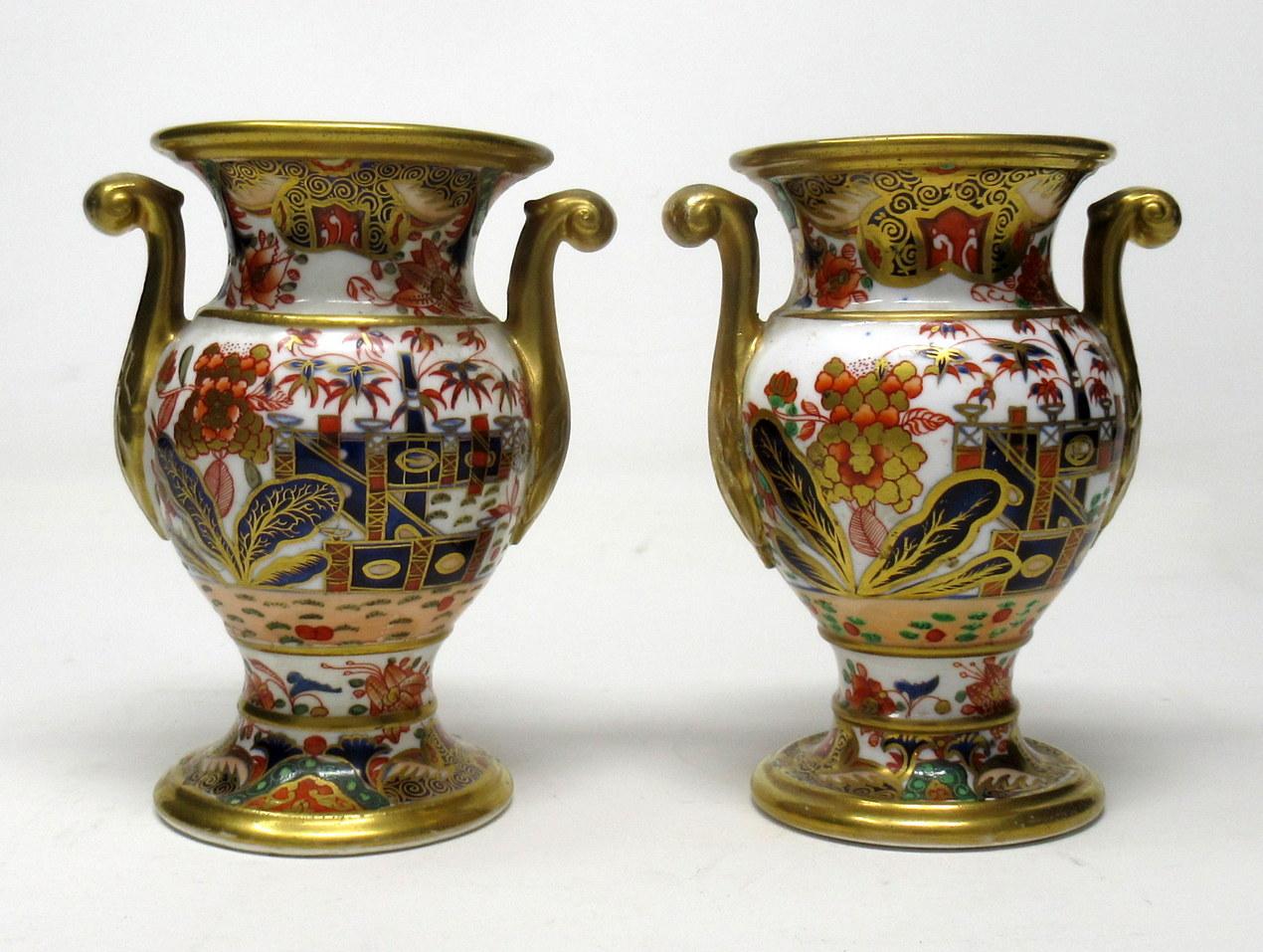 An extremely rare pair of early Spode hand painted identical porcelain vases of classical form and small size, with lavish gilt twin scroll handles, circa 1810. 

Exquisitely painted in typical Oriental Garden scene in Imari palette colors of iron