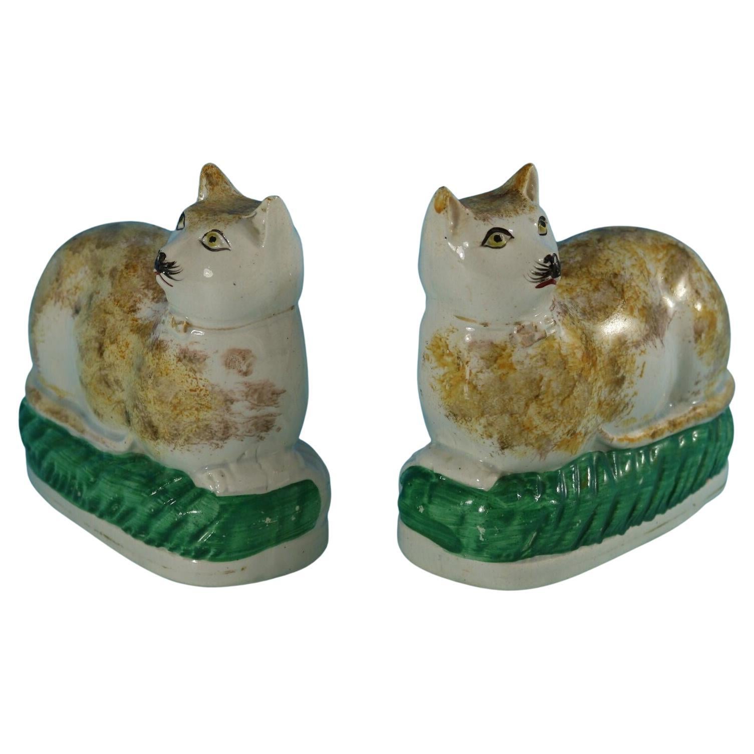 Rare paire de chats sur coussins en poterie du Staffordshire