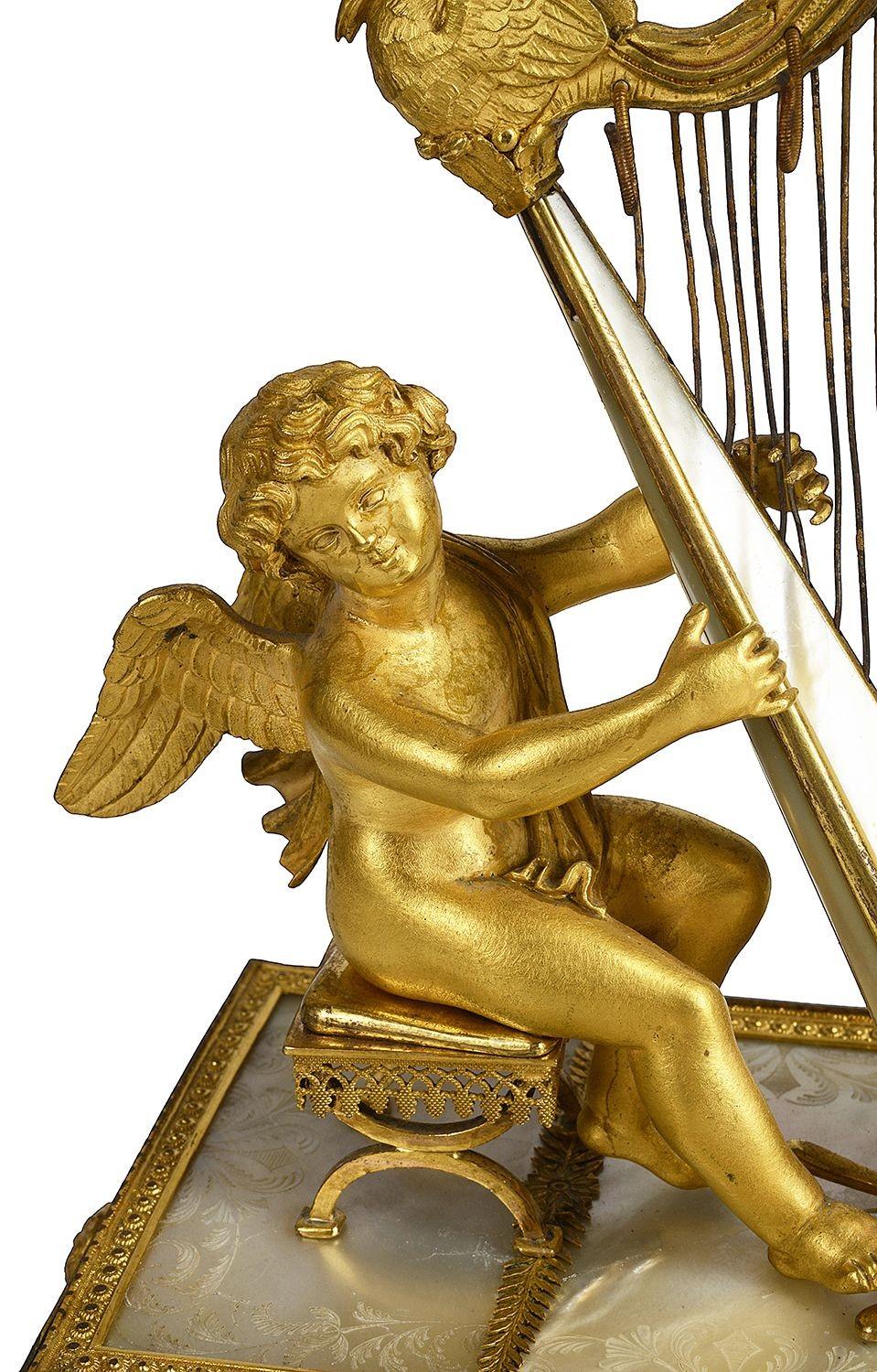 A rare and unusual Palais Royal gilded ormolu and Mother of Pearl music box, in the form of a cherub playing a harp, a velvet lined drawer for jewelery, a cherub seated on a stool while playing the Harp, hooks hanging from the Harp to hold rings,