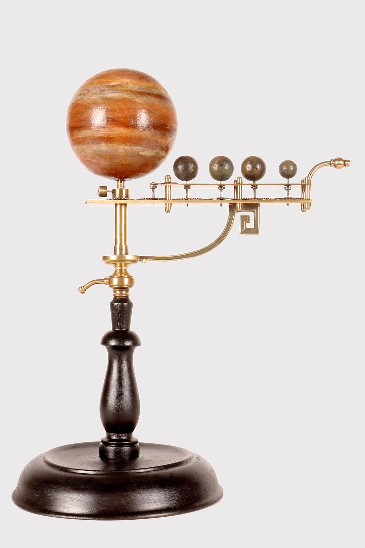This rare paradoxical planetarium demonstrates the rotation and revolution motion of the system of the planet Jupiter and the Medici satellites. The base is made of ebonized fruit wood, circular in shape with a profile that narrows upwards, marked