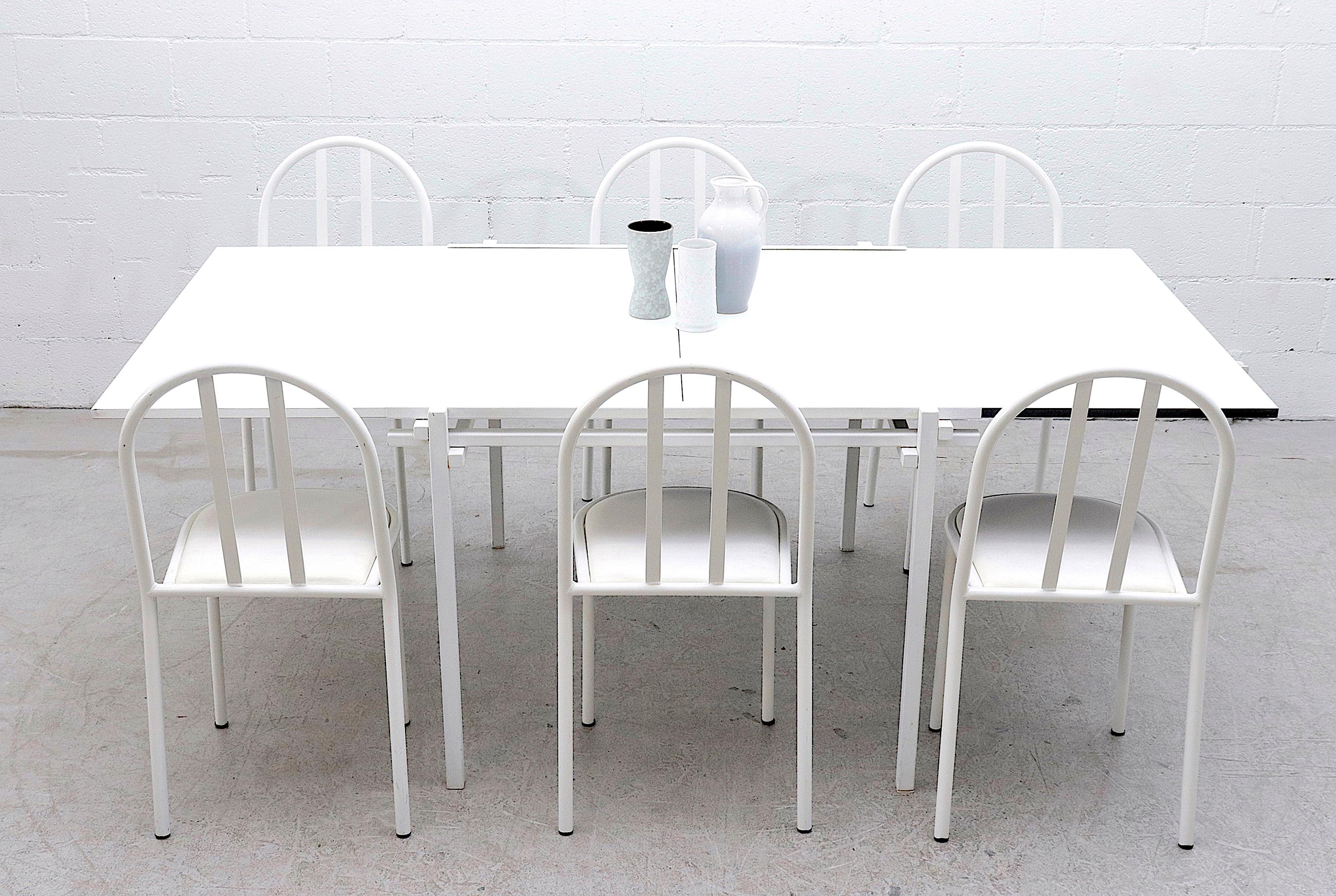 Unique midcentury dining table with double white square table tops and white enameled metal frame. This impressive two tiered dining table doubles in size by aligning both table tops in a sturdy shared groove to make dining space for 6-8 chairs. In