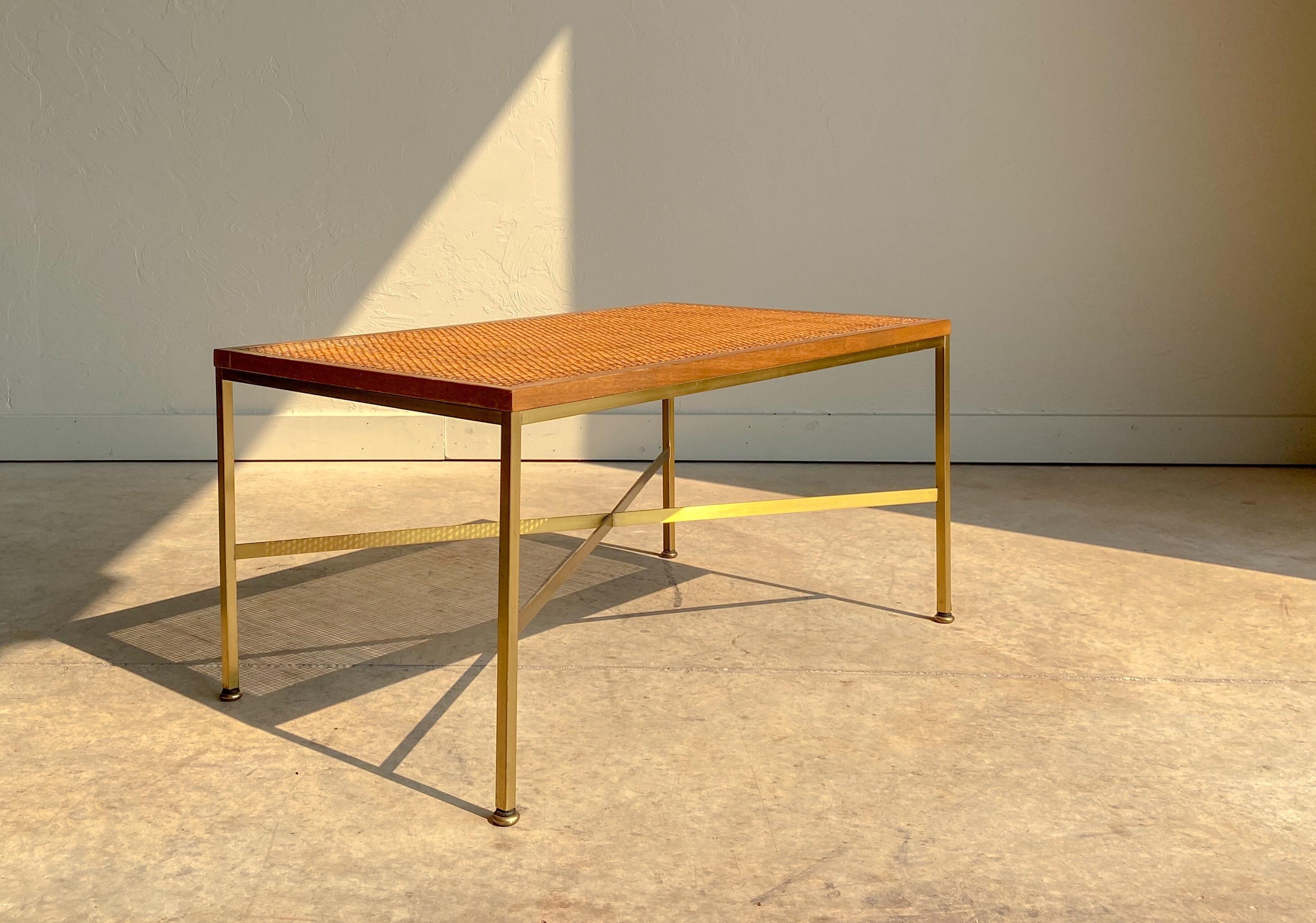 A rare Paul McCobb brass and rattan bench for Calvin. 

Model 7709 is a petite bench that would be well suited for an entryway or at the foot of a bed. 

The combination of polished brass and rattan provides a wonderful warmth and elegance to